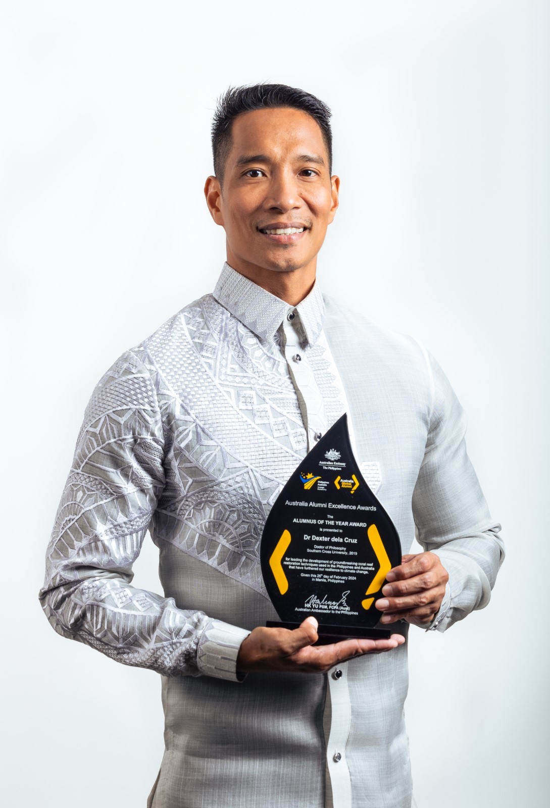 Man smiling holding an award