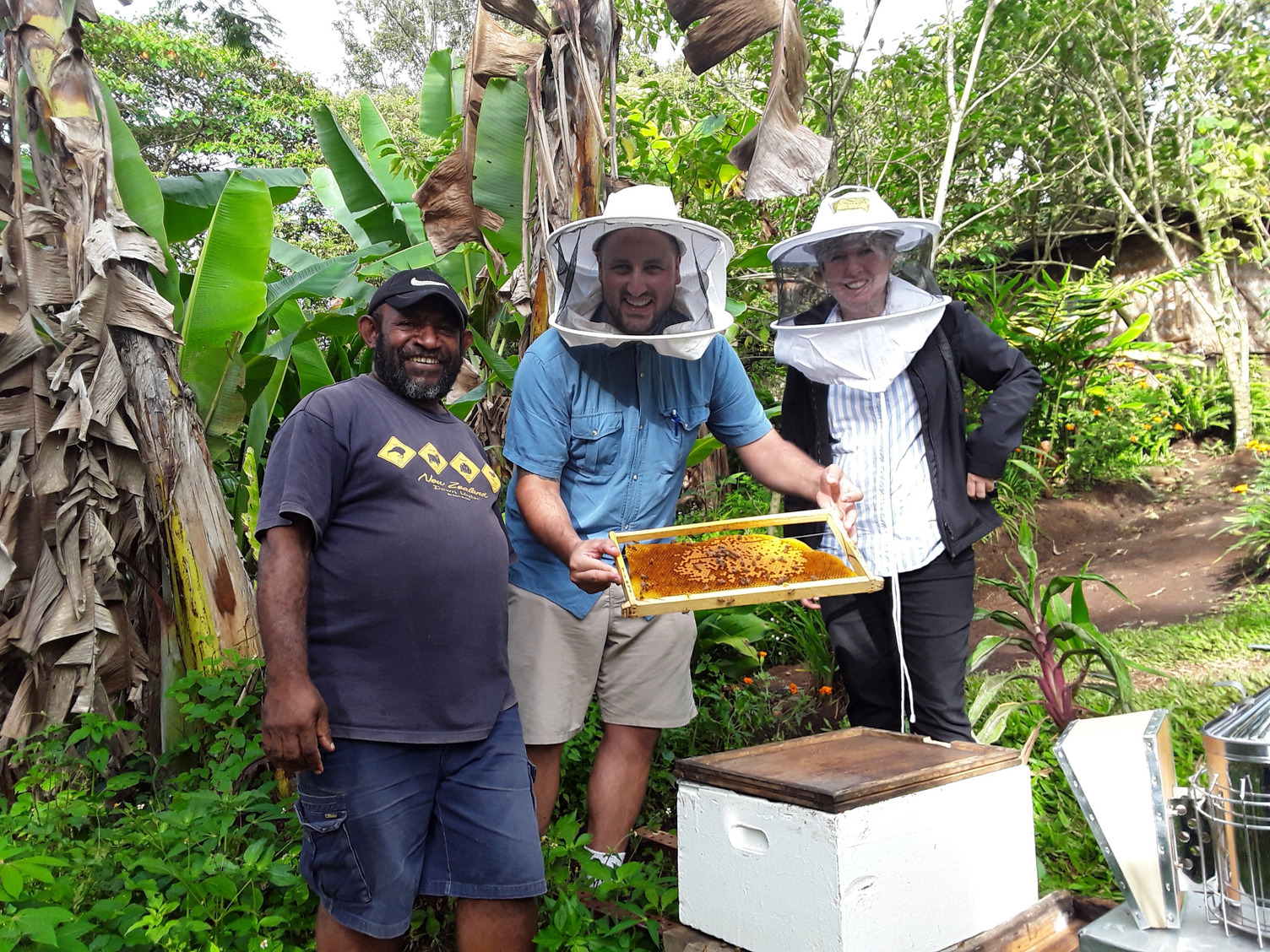 (L-R) Head of Helping hands Honey production Kelly Inae, showing Chris Cannizzaro and Professor Helen Wallace pollen frames from his hives in Goroka. Research has just been concluded on the composition of bee diets in PNG that will provide useful information for improved honey production. Photo supplied by Chris Cannizzaro.