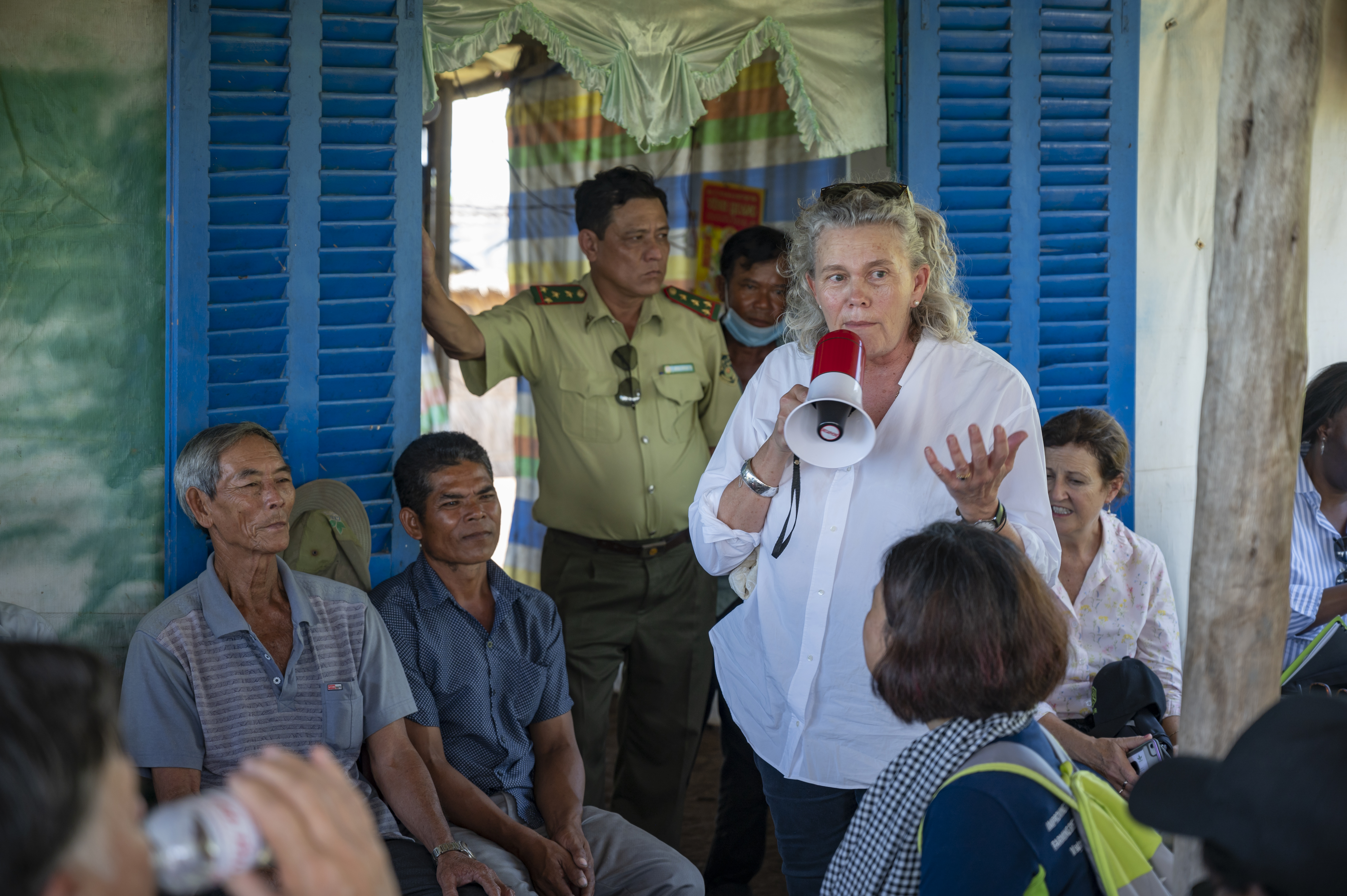 Woman speaking into speaker to a group