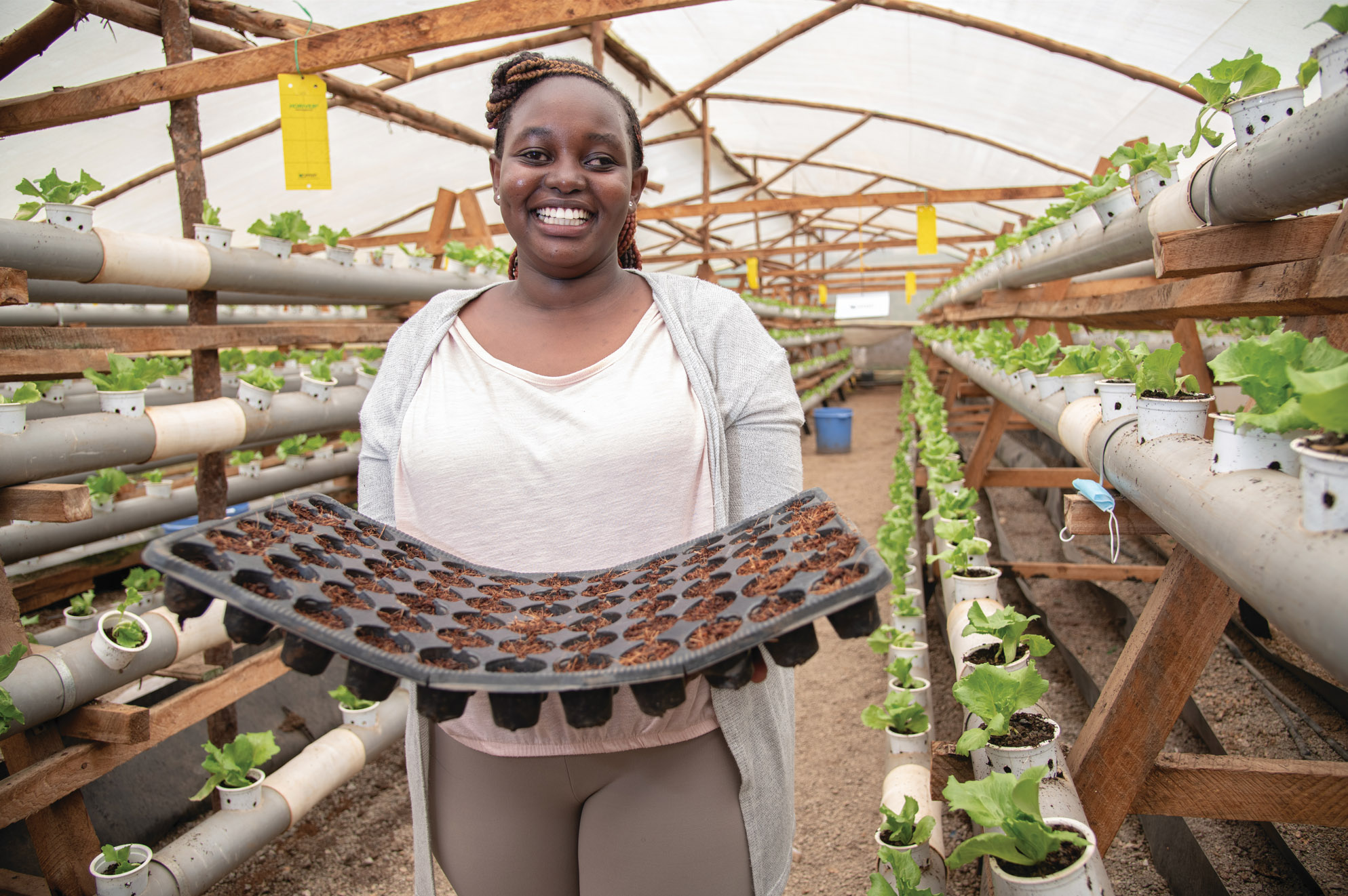 A smiling woman holding seedlings