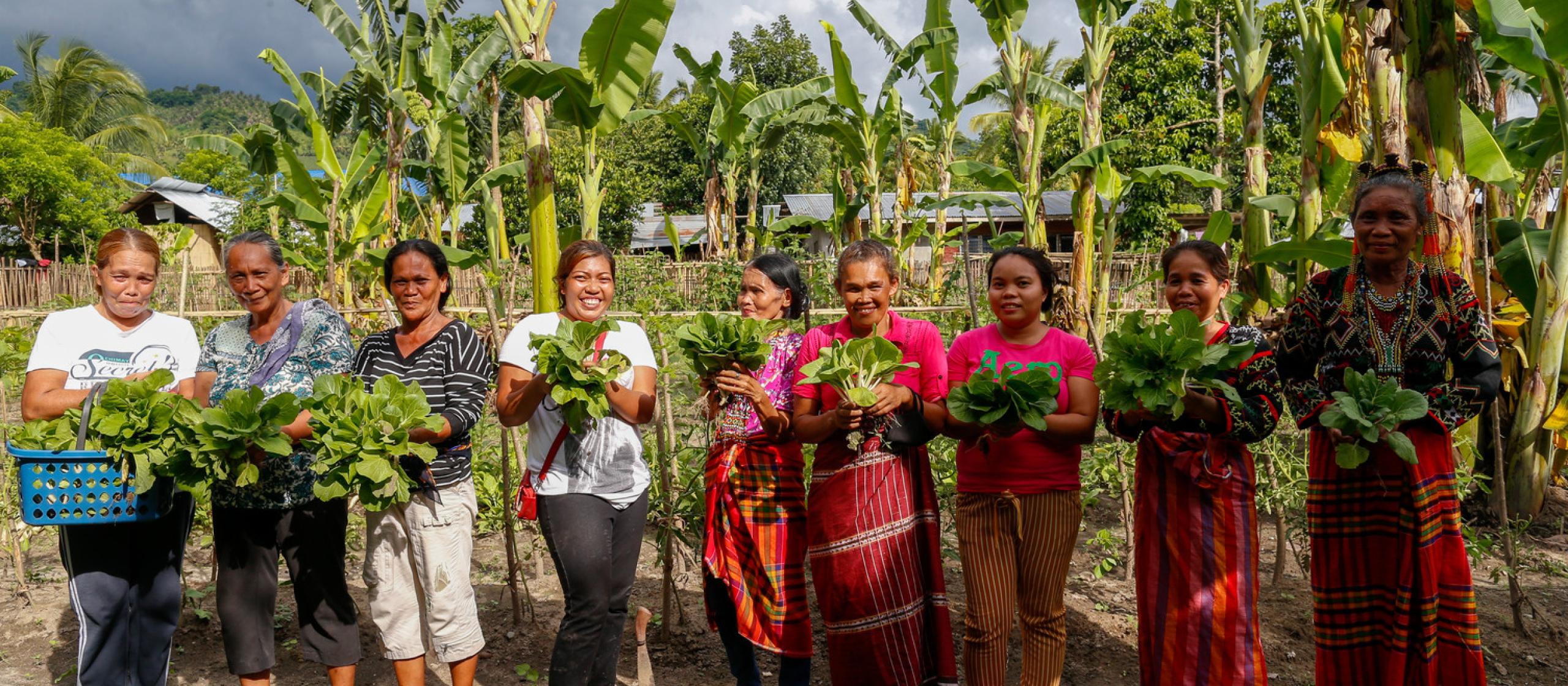  Women show the vegetables they harvest from their community garden in Paraiso village in Koronadal City in the Southern Philippine Province of South Cotabato, Mindanao