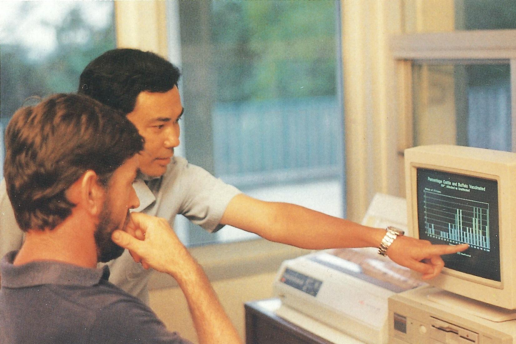 2 men looking and pointing at a results on a computer screen