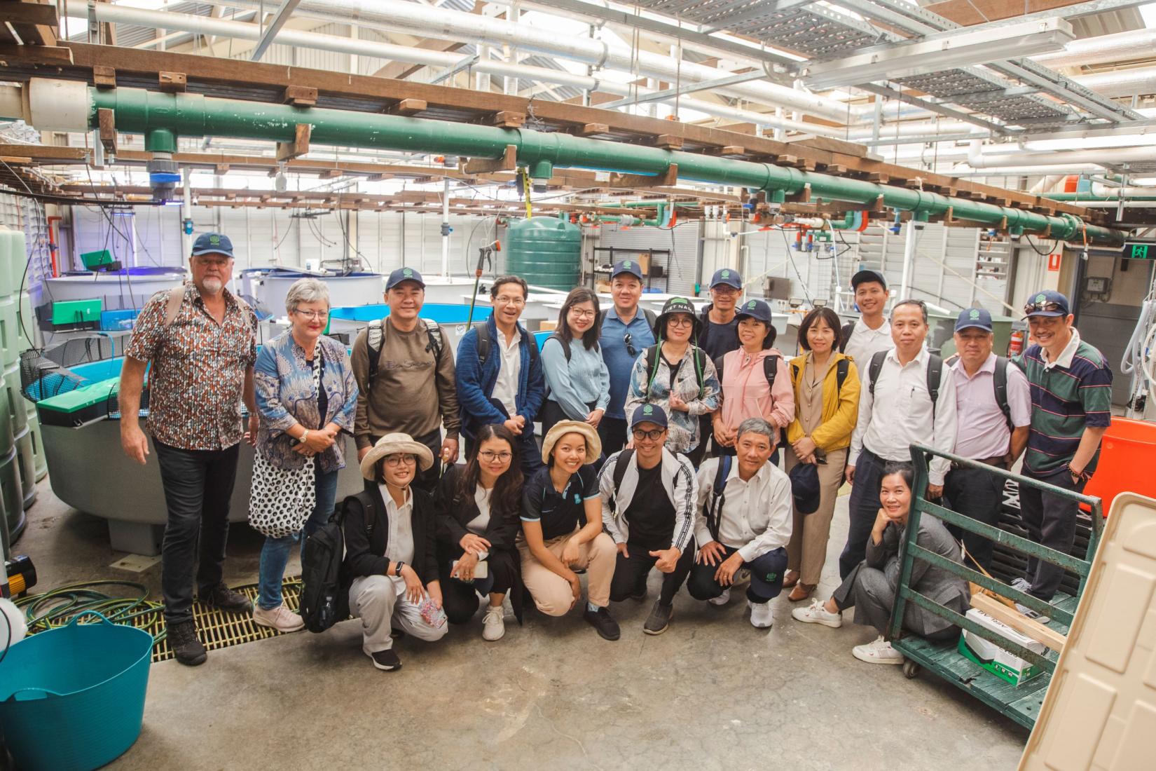 A group of people smiling visiting a research facility