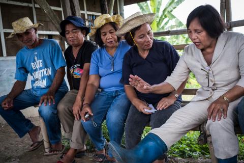 Dr Ana Notarte (right) and Riza Calma (second right) with other farmers discussing the important of boot hygiene.