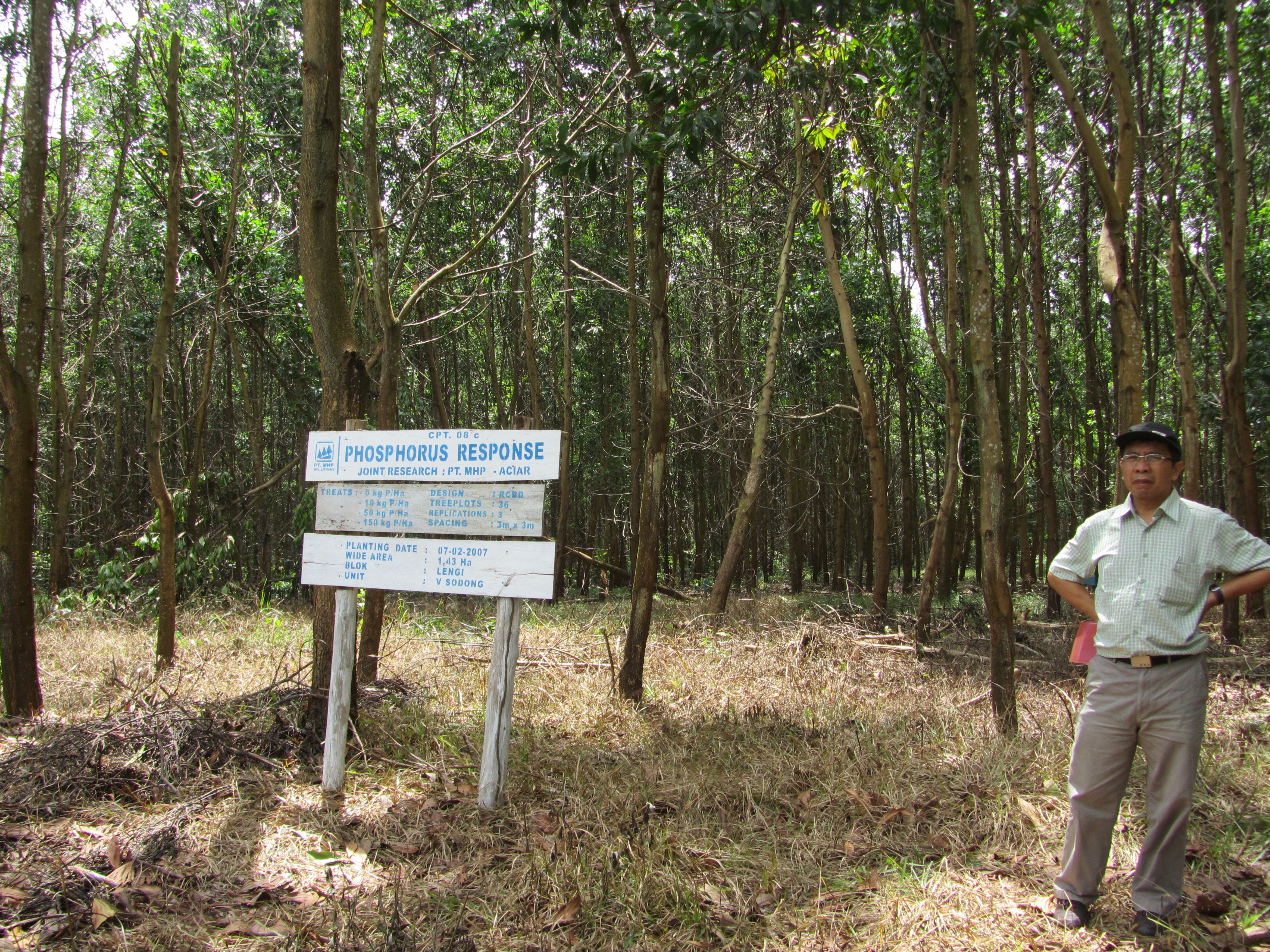 A man stands in front of the fertiliser sign
