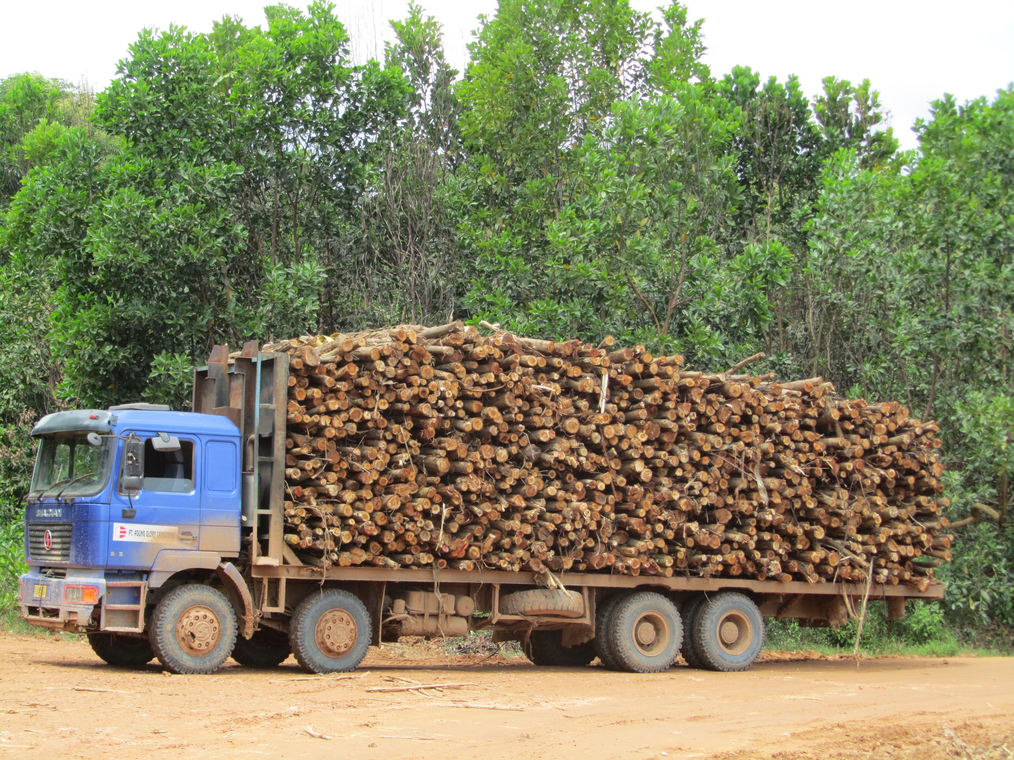 A logging truck moves stacks of timber