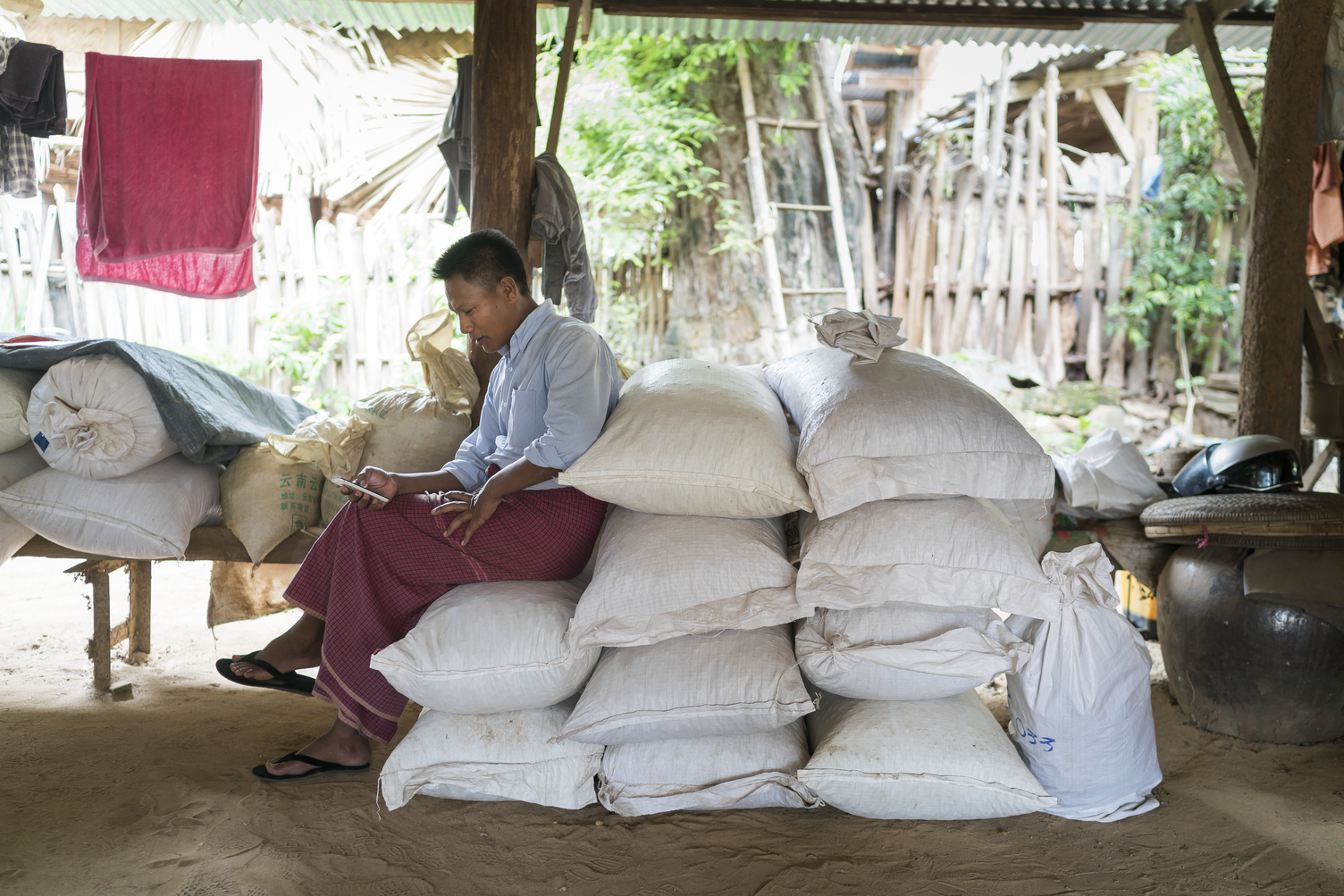 man sitting on bags of pulses