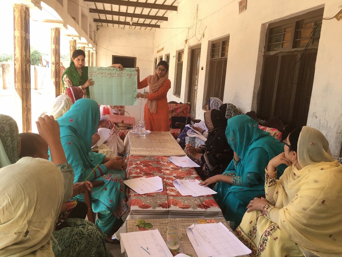 Group of women in saris in an outdoor classroom environment