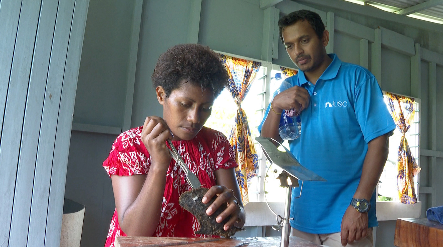 Dr Kishore guiding women on oyster shell cleaning process