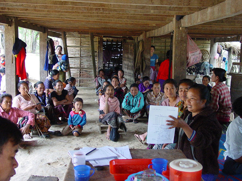 A group of women having a meeting under a wooden awning