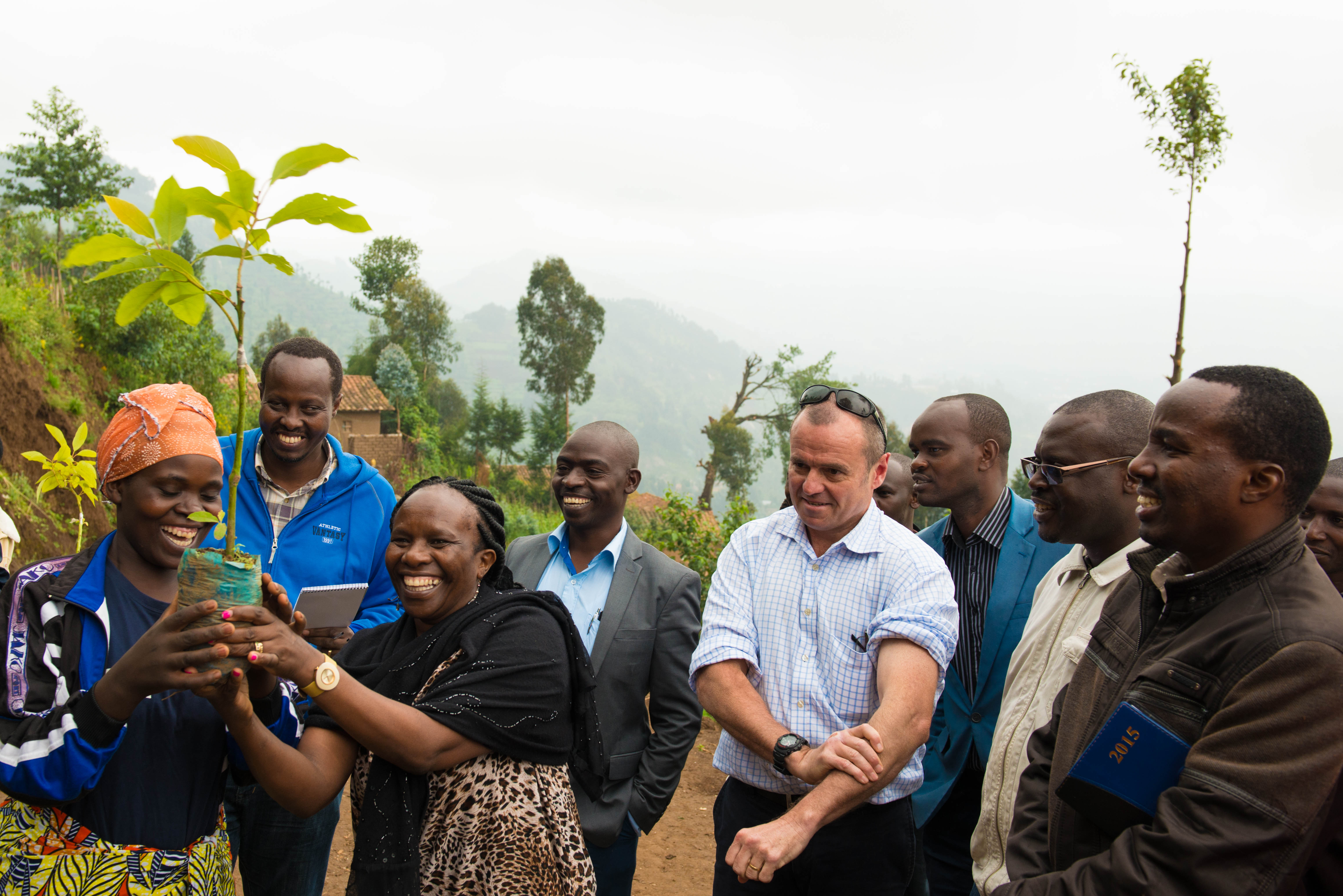 Catherine handing over a fruit tree seedling to a farmer in Rwanda, Australian High Commissioner H E John Feakes (centre) looking on Photo Ake Mamo-ICRAF