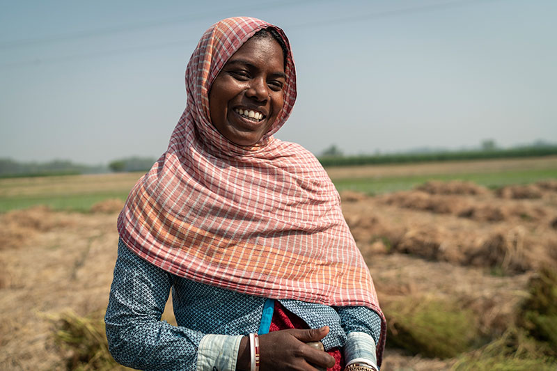 A woman with headscarf standing in a field