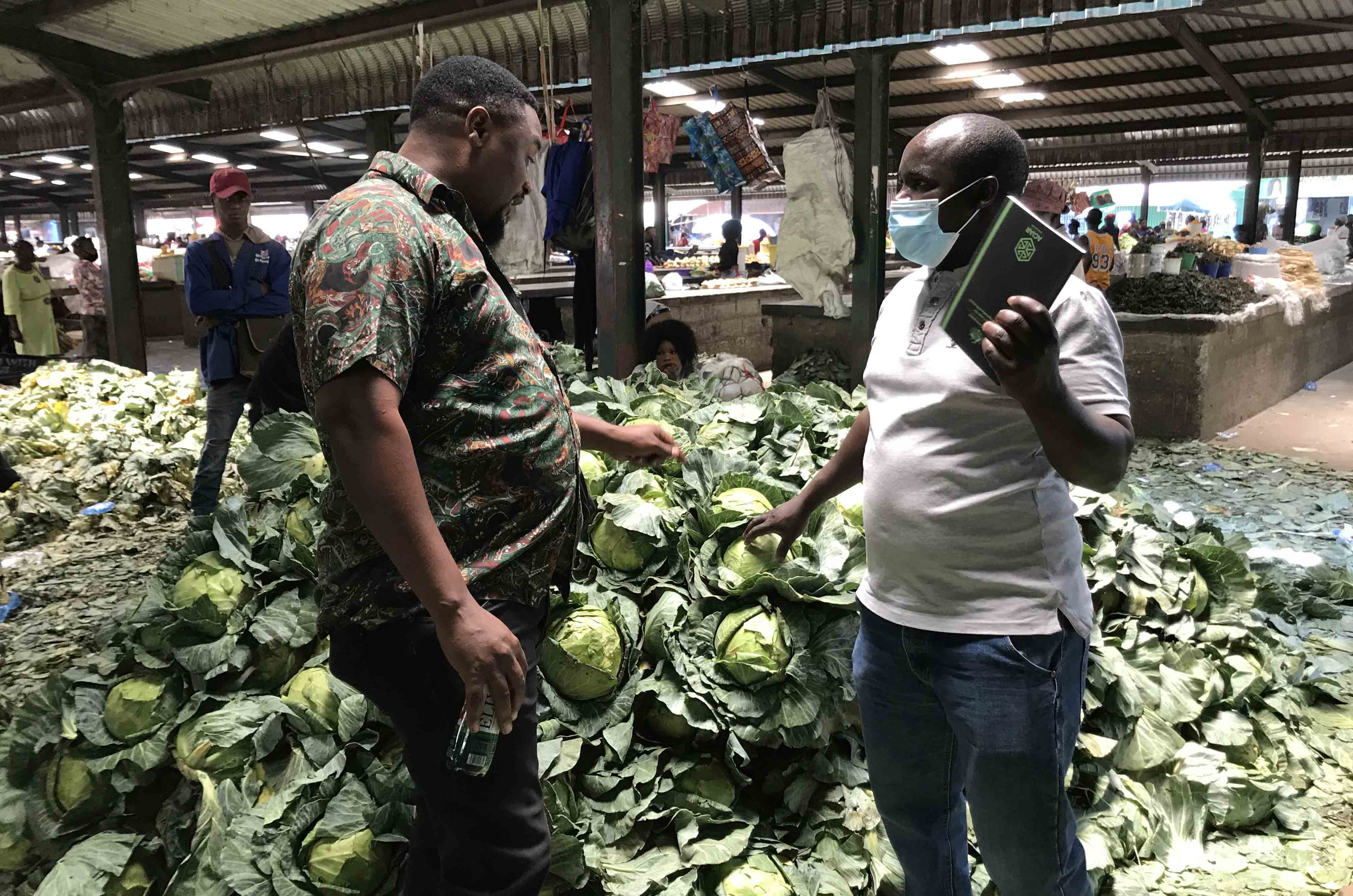 Researcher examining produce at markets in Lusaka, Zambia.