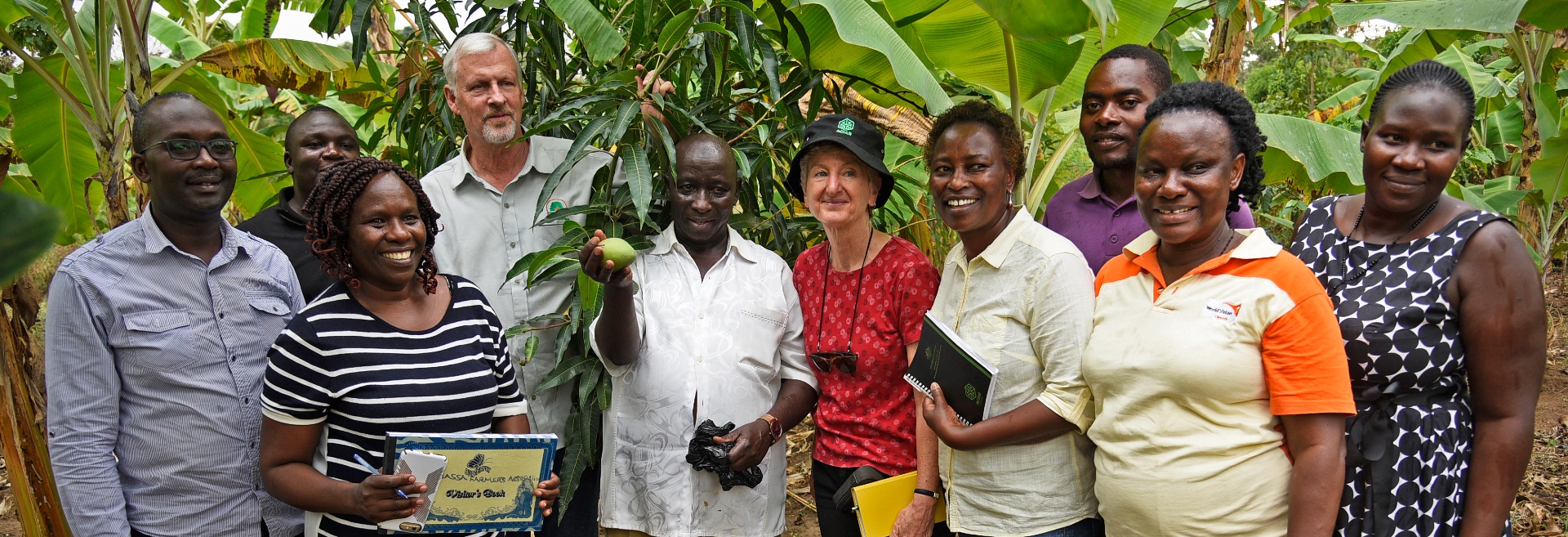 Group of people smiling and standing in front of trees