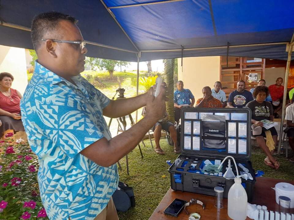 Man in blua shirt demonstrates soil testing technique