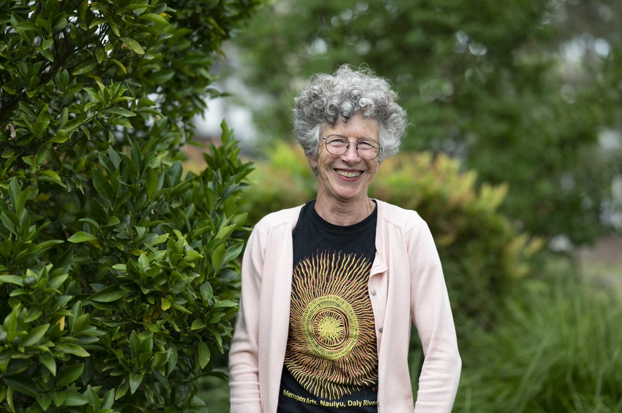 Woman smiling with trees in the background