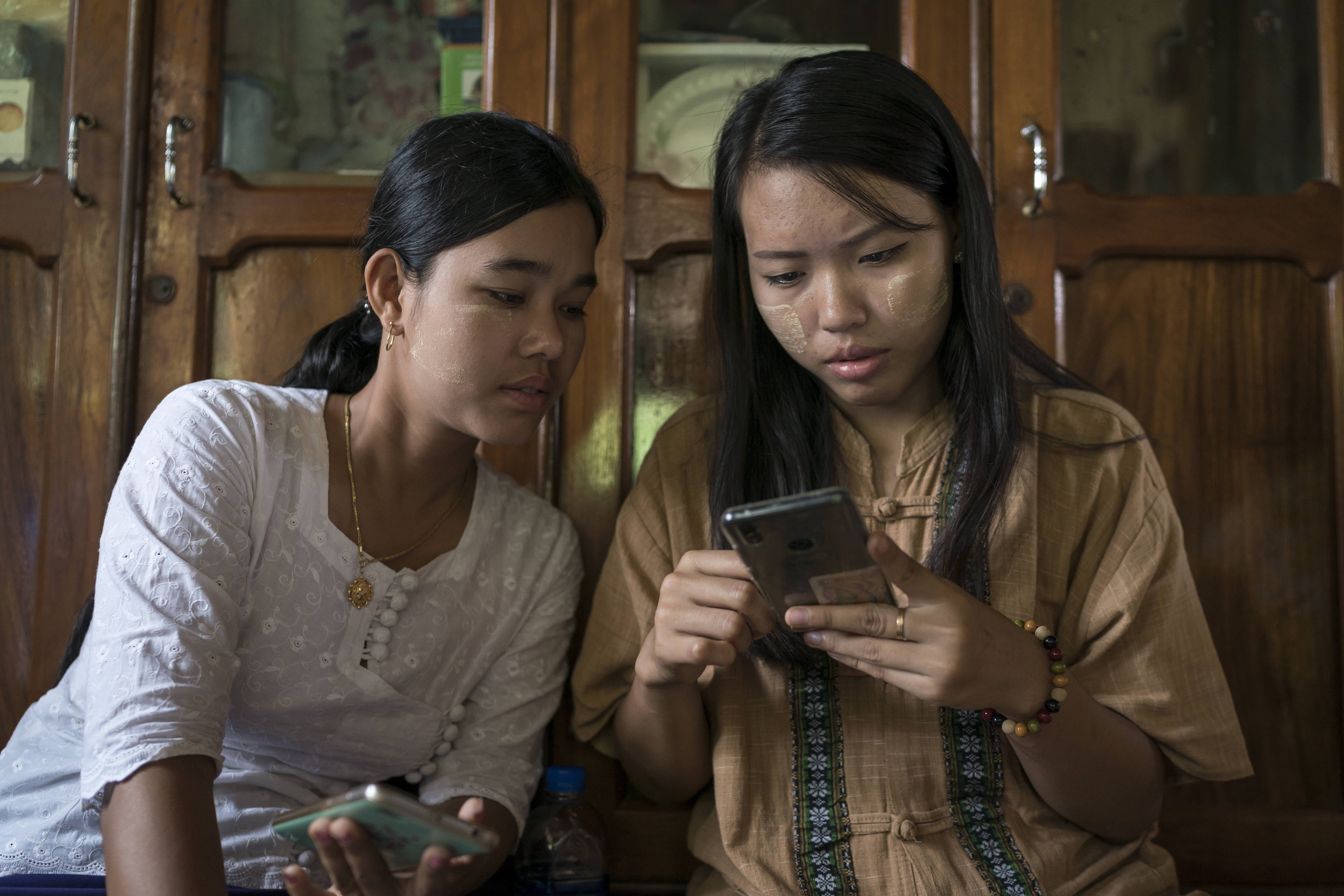 Two people reading from a smart phone