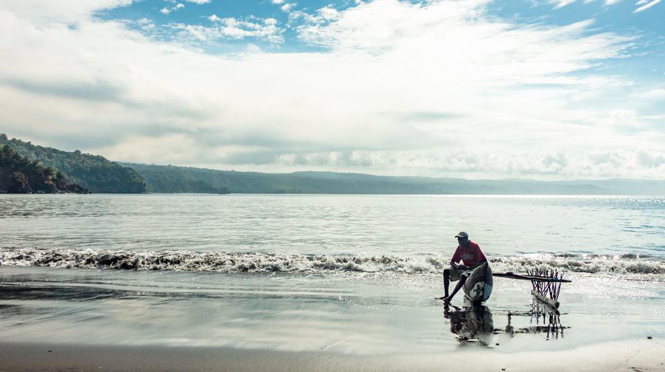 a fisherman sitting on the sea shore
