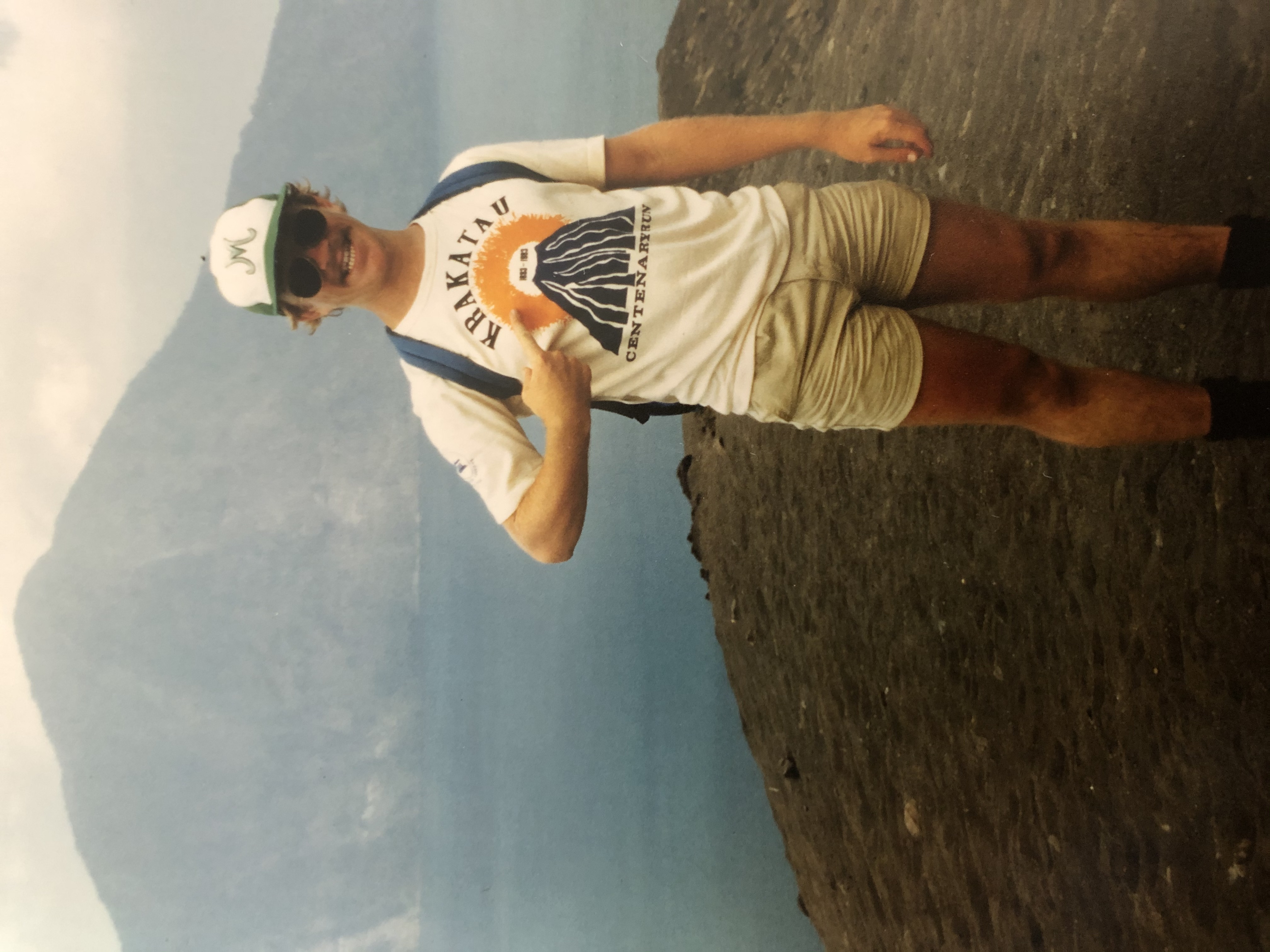 Man pointing at t-shirt with volcano in the distance