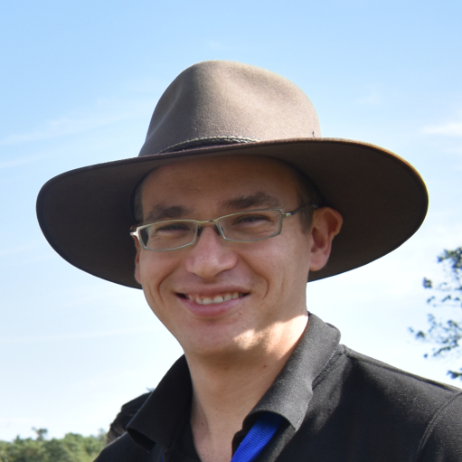 Man smiling at camera wearing a hat