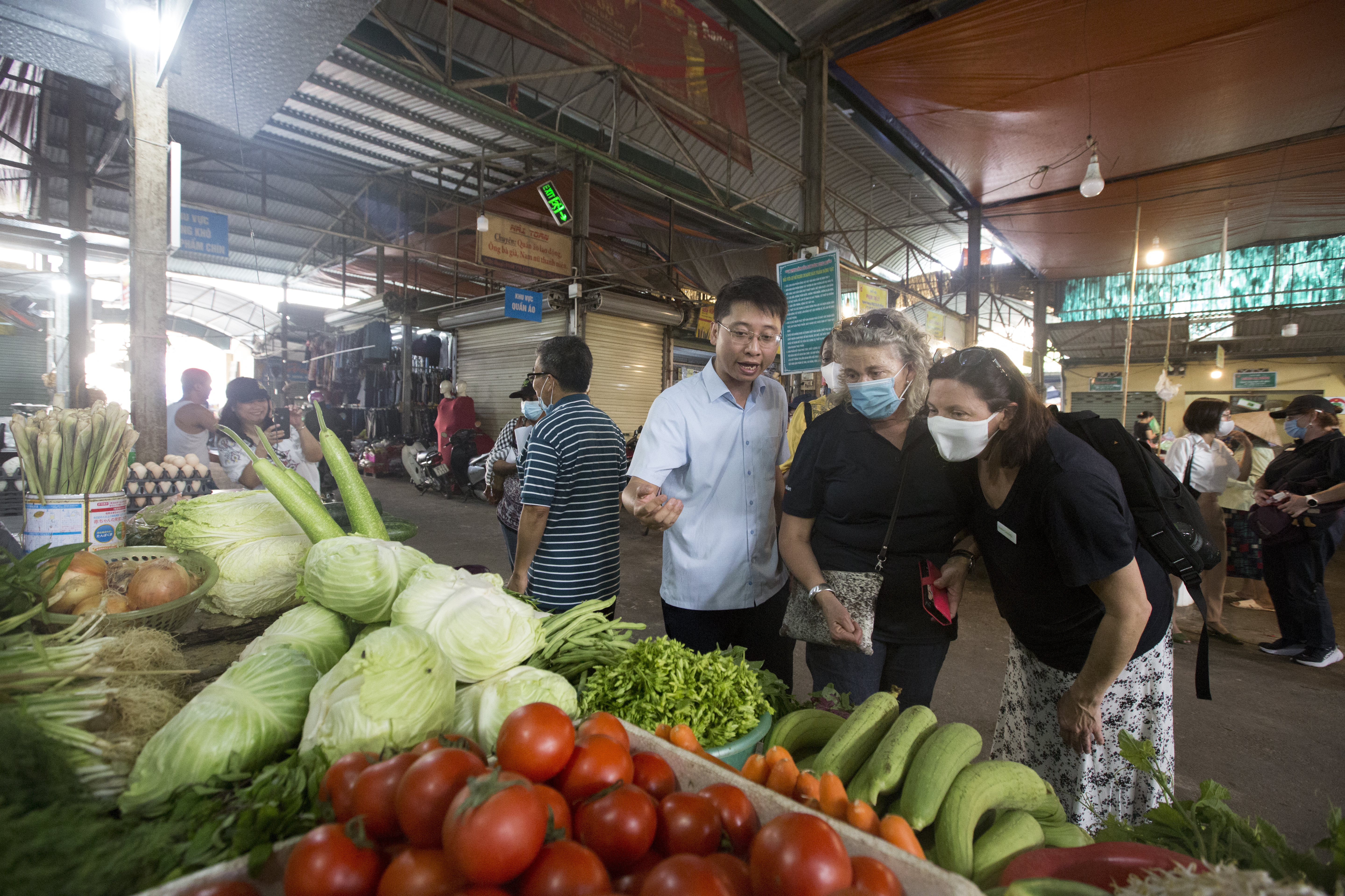 People inspecting produce at a market
