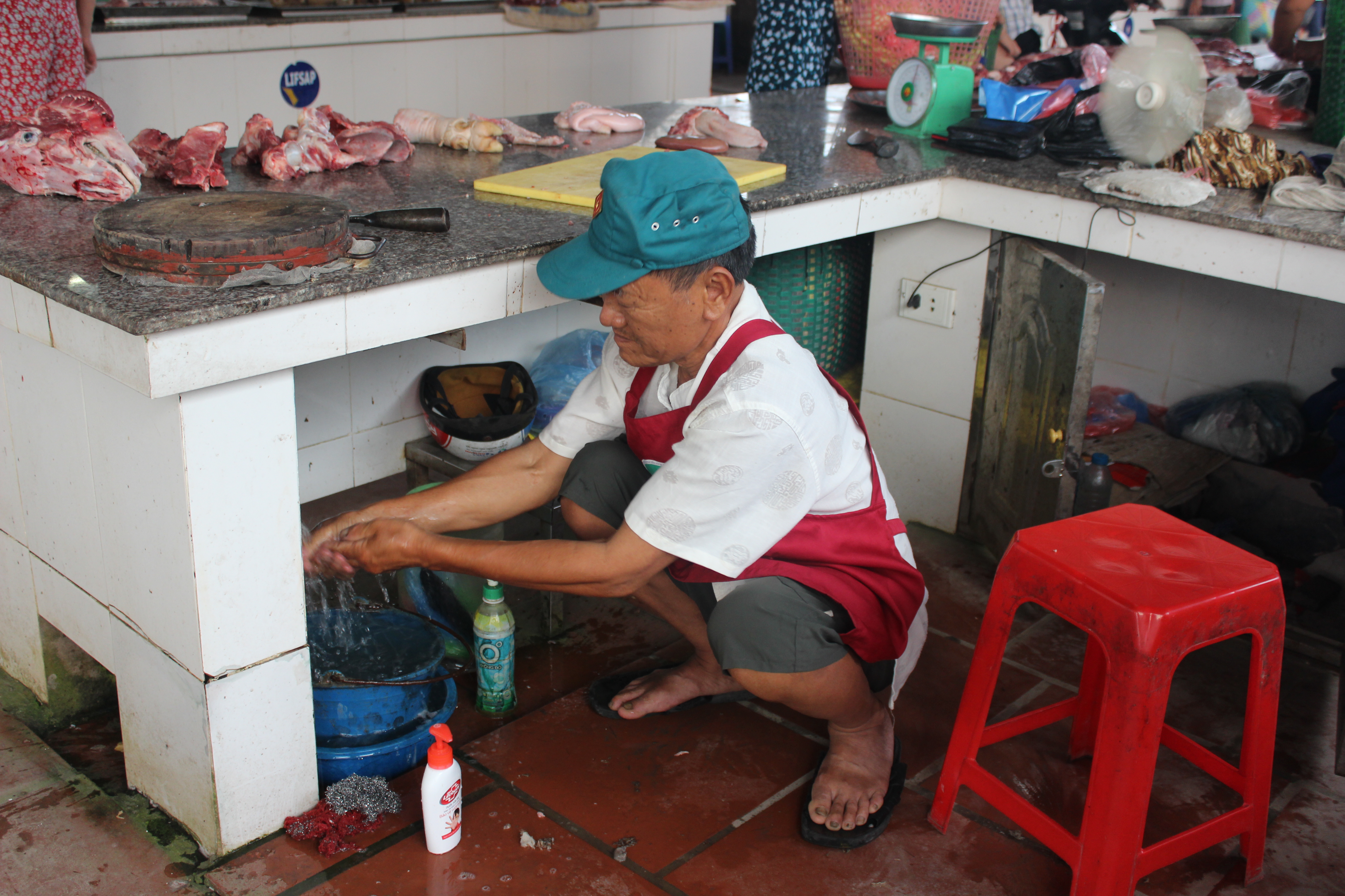 A pork retailer in Vietnam washes their hands