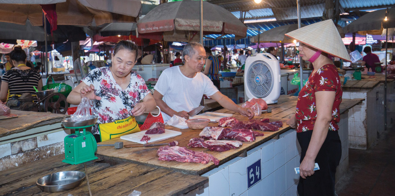People inspecting pork at markets