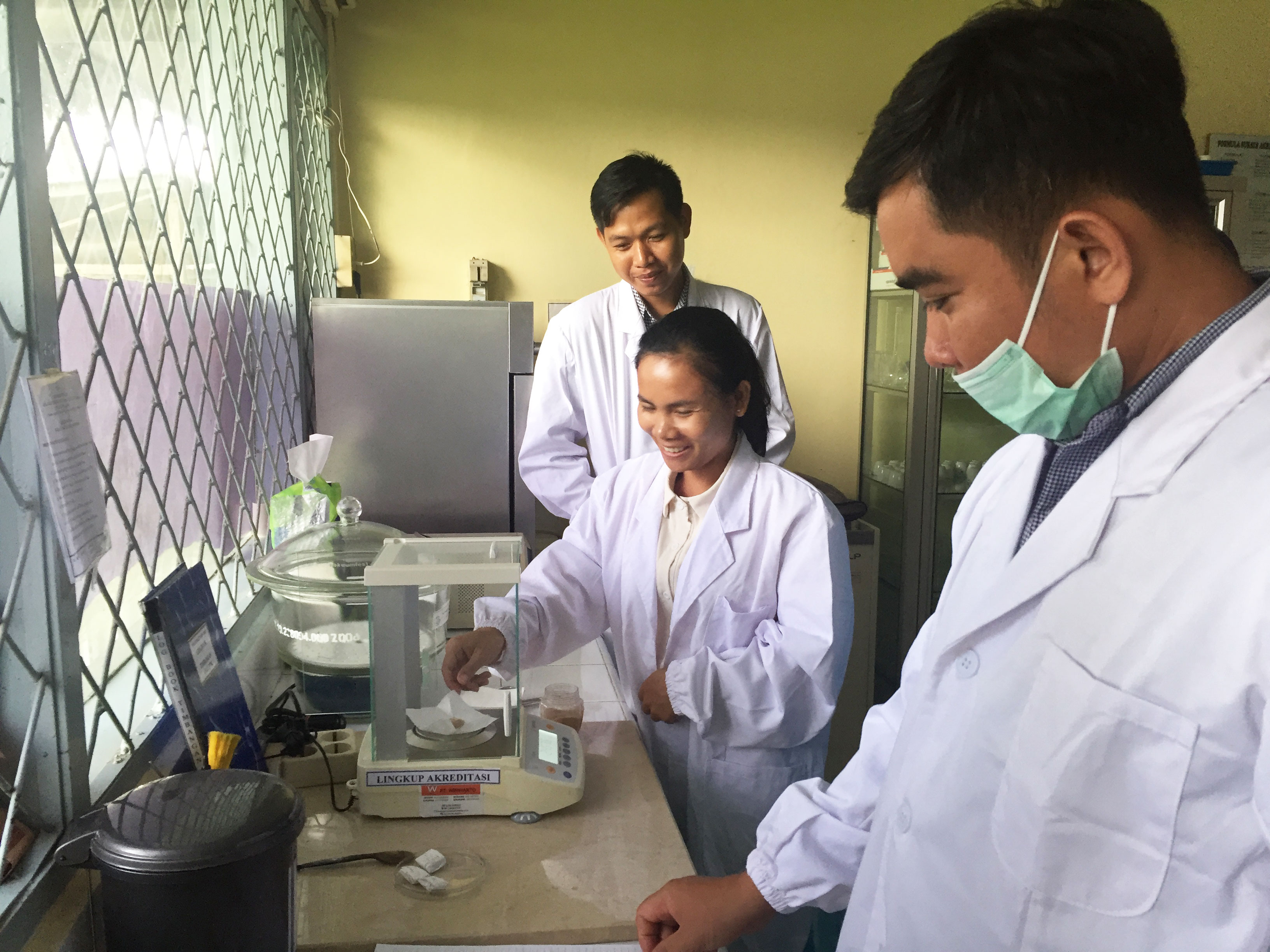 3 people in white lab coats in a labroratory in Asia