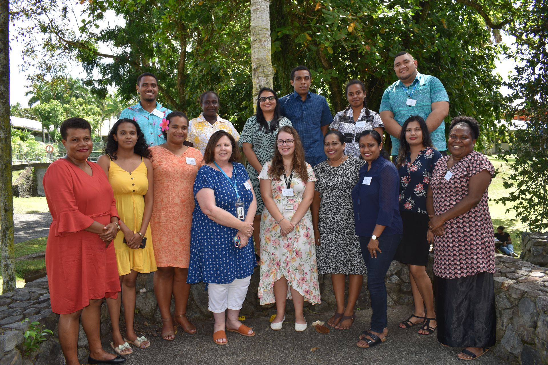 Group of people smiling and standing in front of trees