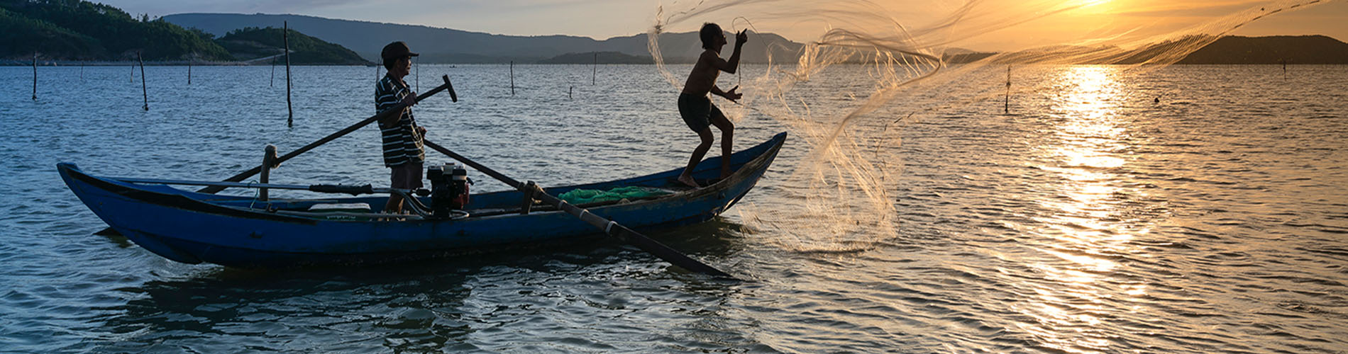 two people on a canoe on water, at sunset