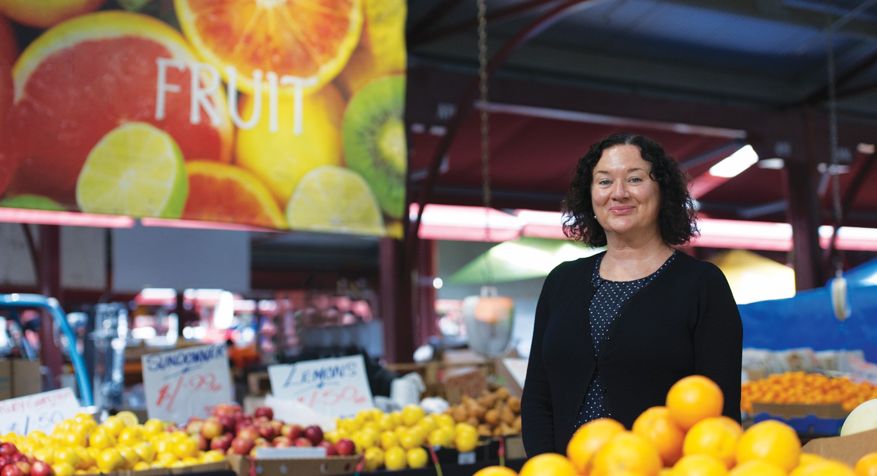 woman standing in middle of fruit market