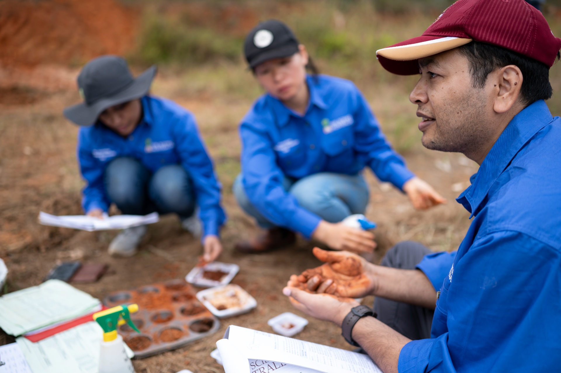 3 perople analysing and discussing soil samples