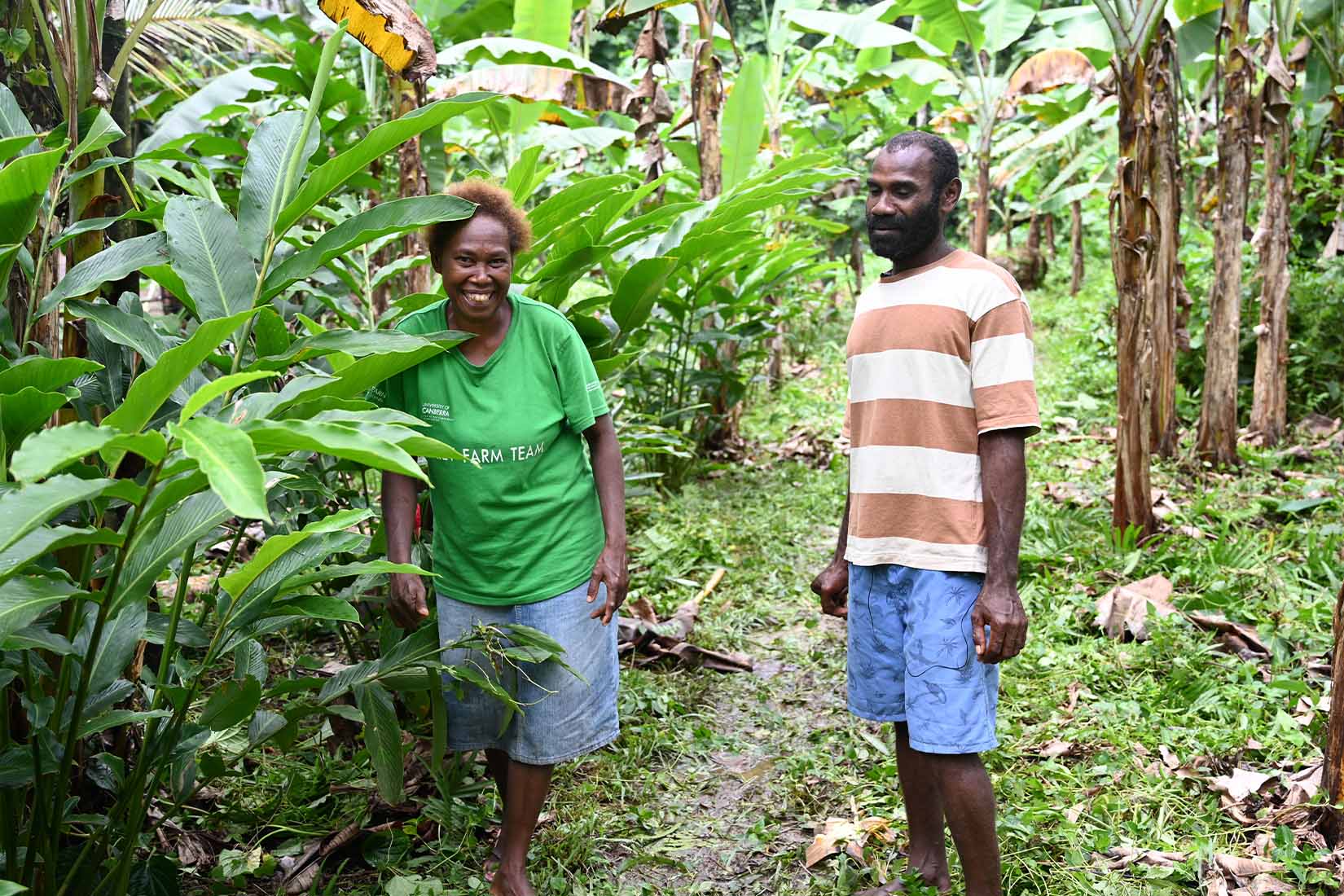 Two people standing in a forest smiling