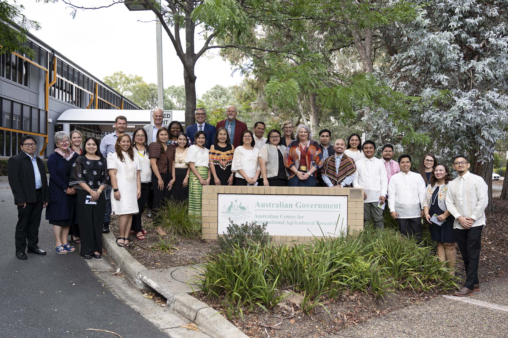 John Dillon fellows standing next to the ACIAR sign