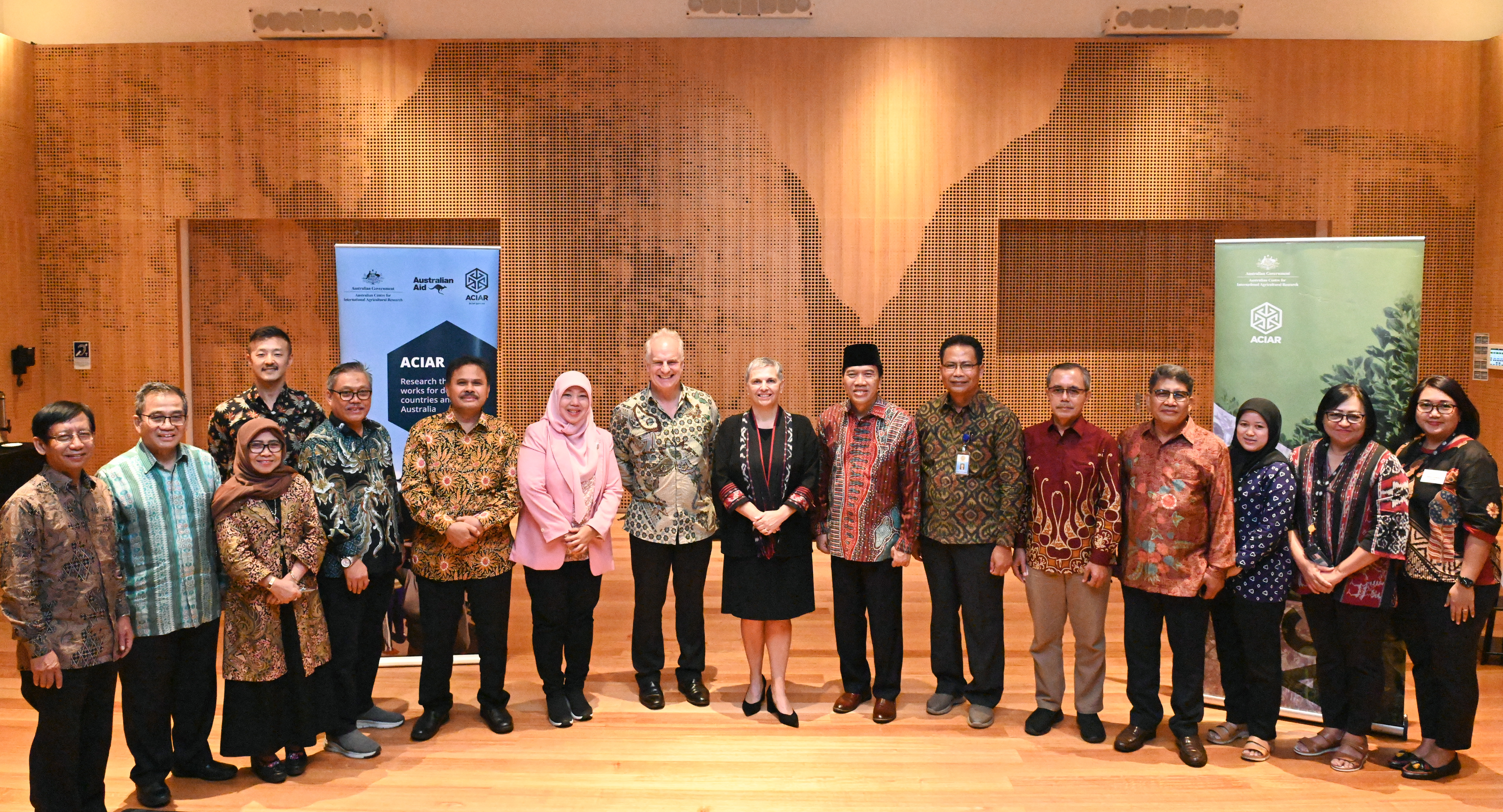 Group of people standing in meeting room for photo and smiling