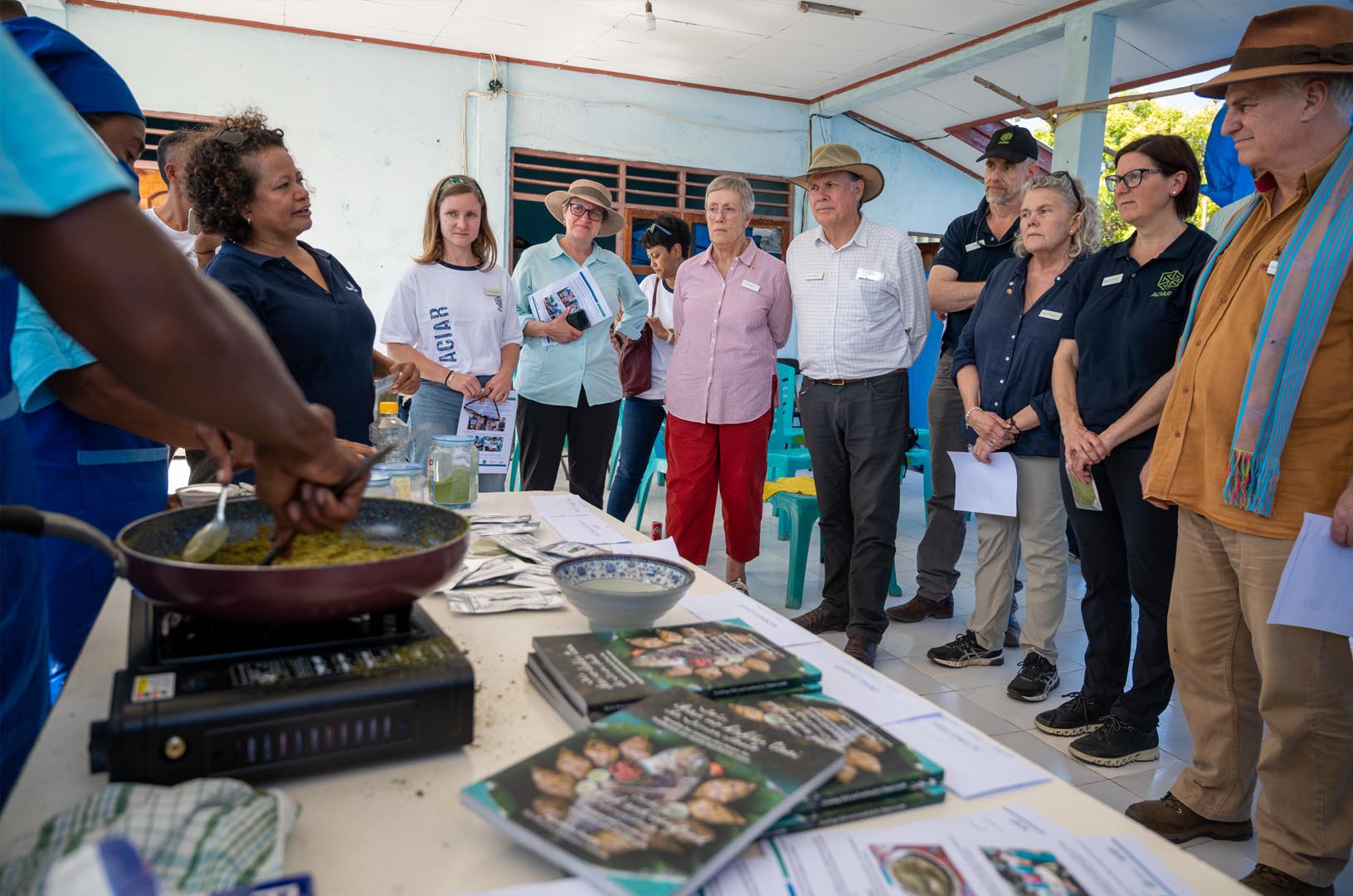 Commissioners watch on during a cooking demonstration at a WorldFish-led initiative to improve human health and nutrition by including fish powder in popular recipes. 