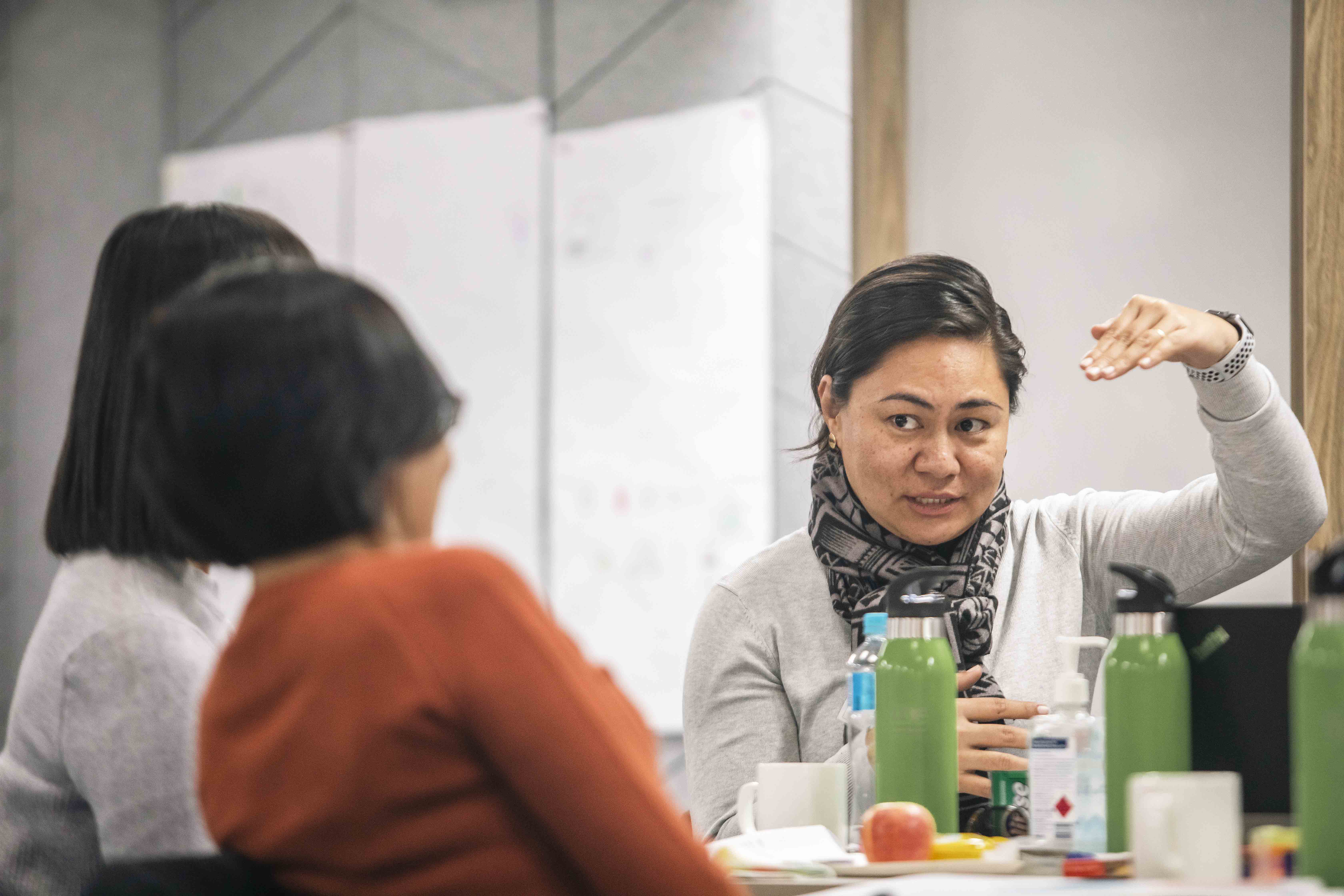 a woman gesturing talking in a group