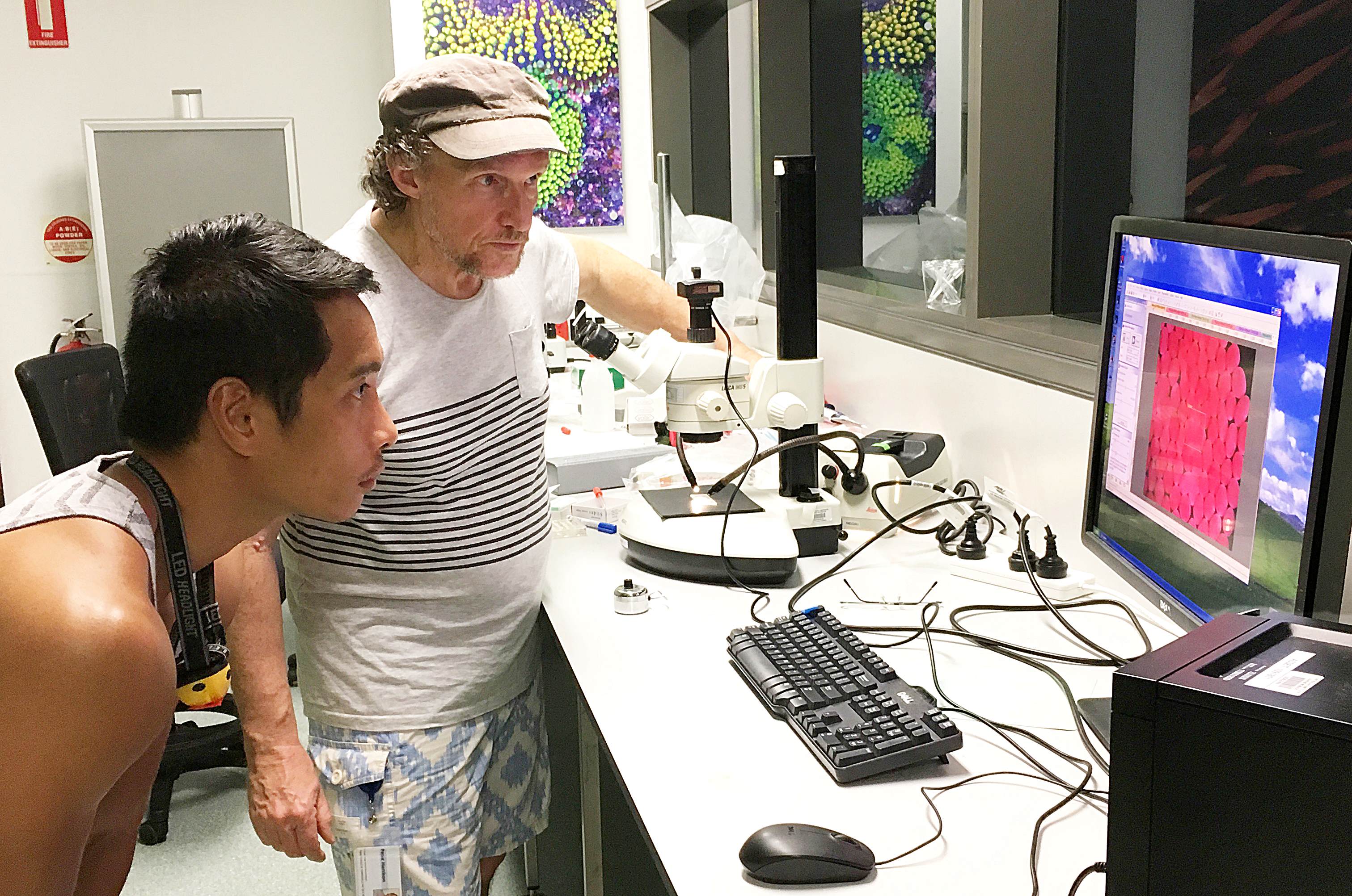 Men in laboratory looking at a computer monitor