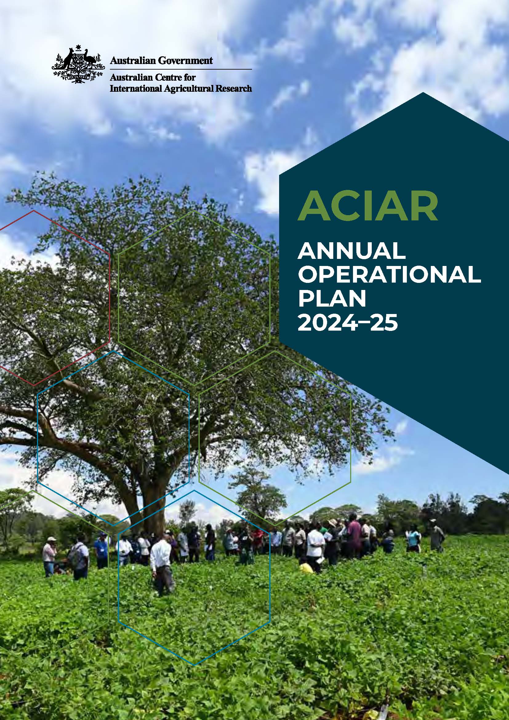 Cover page of the publication, which is a photograph of about 30 people standing beneath a large tree, talking to each other. The tree and people are in a field of low growing green plants.