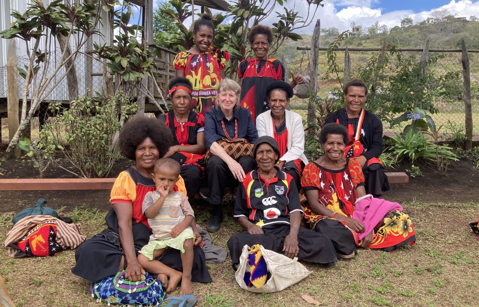 Group of women sitting outside smiling at the camera
