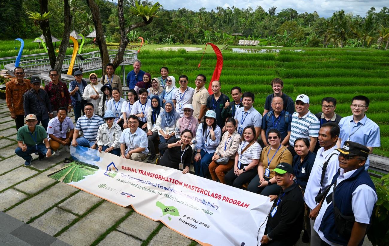 Group of people standing outside in front of a banner