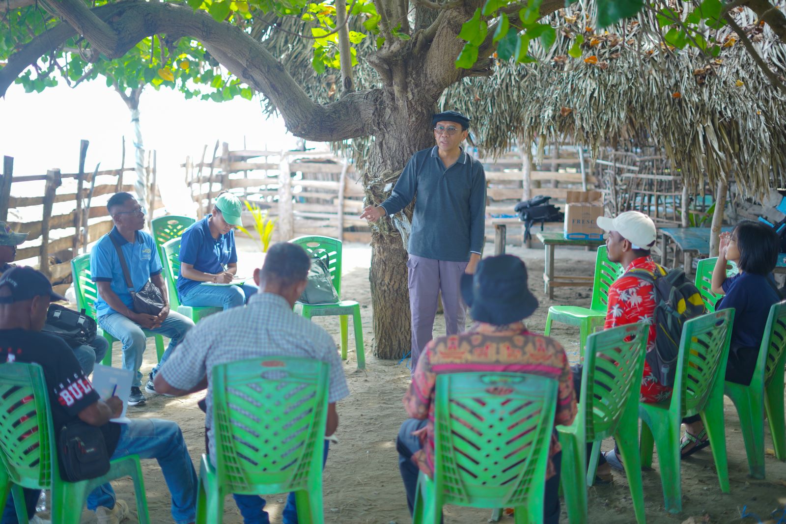 Man speaking to a group of people sitting in a circle