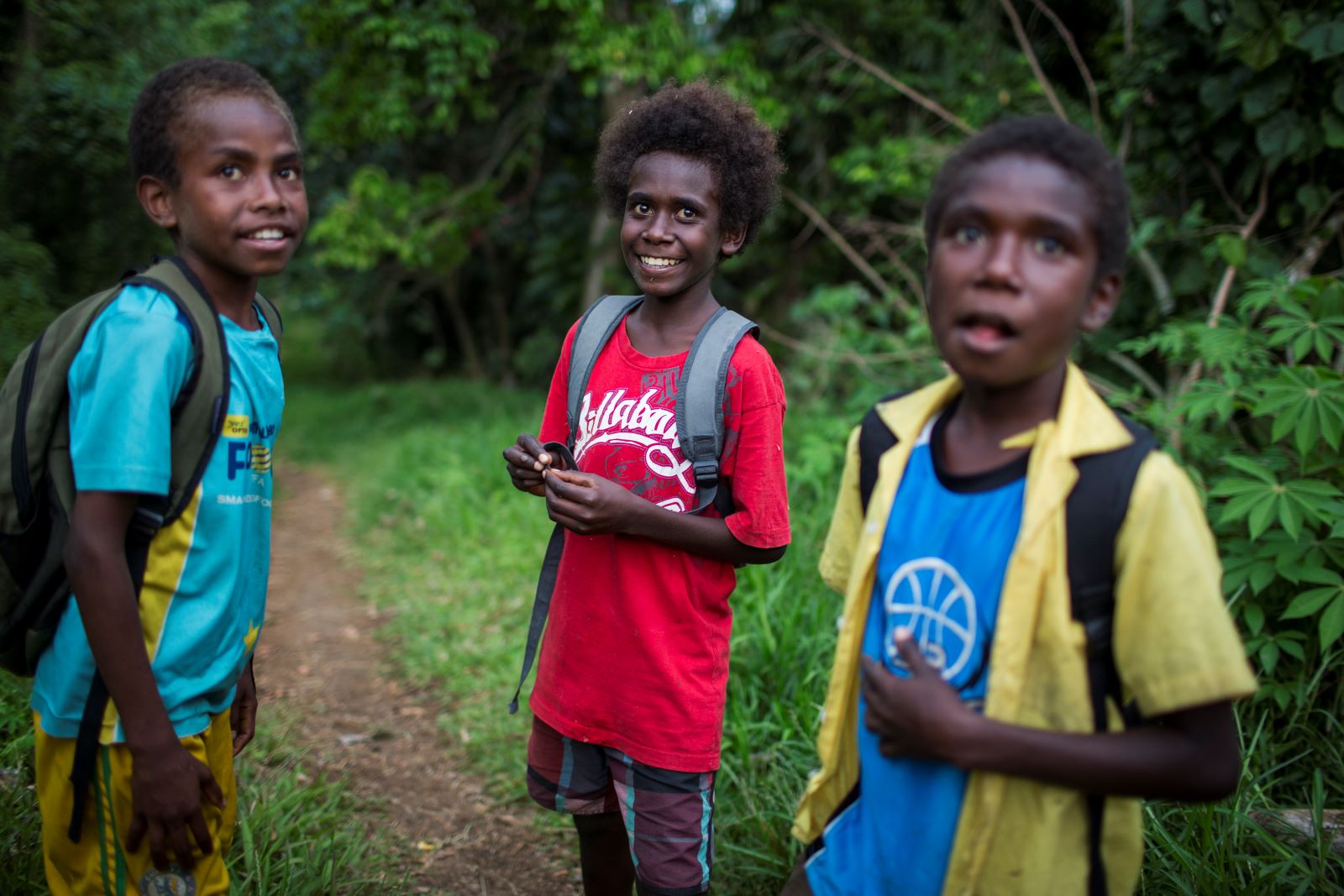 Children standing together wearing backpacks