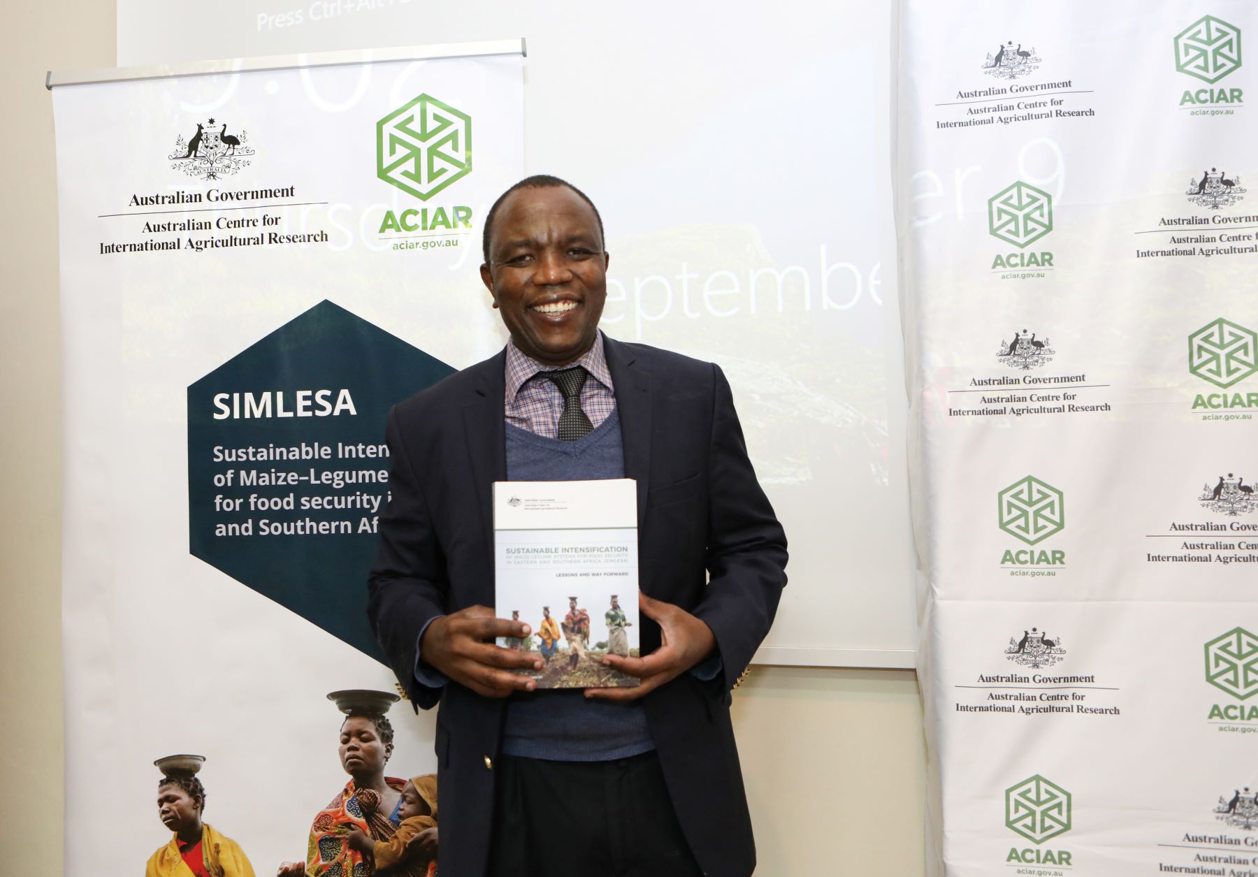 A man holding a book and smiling