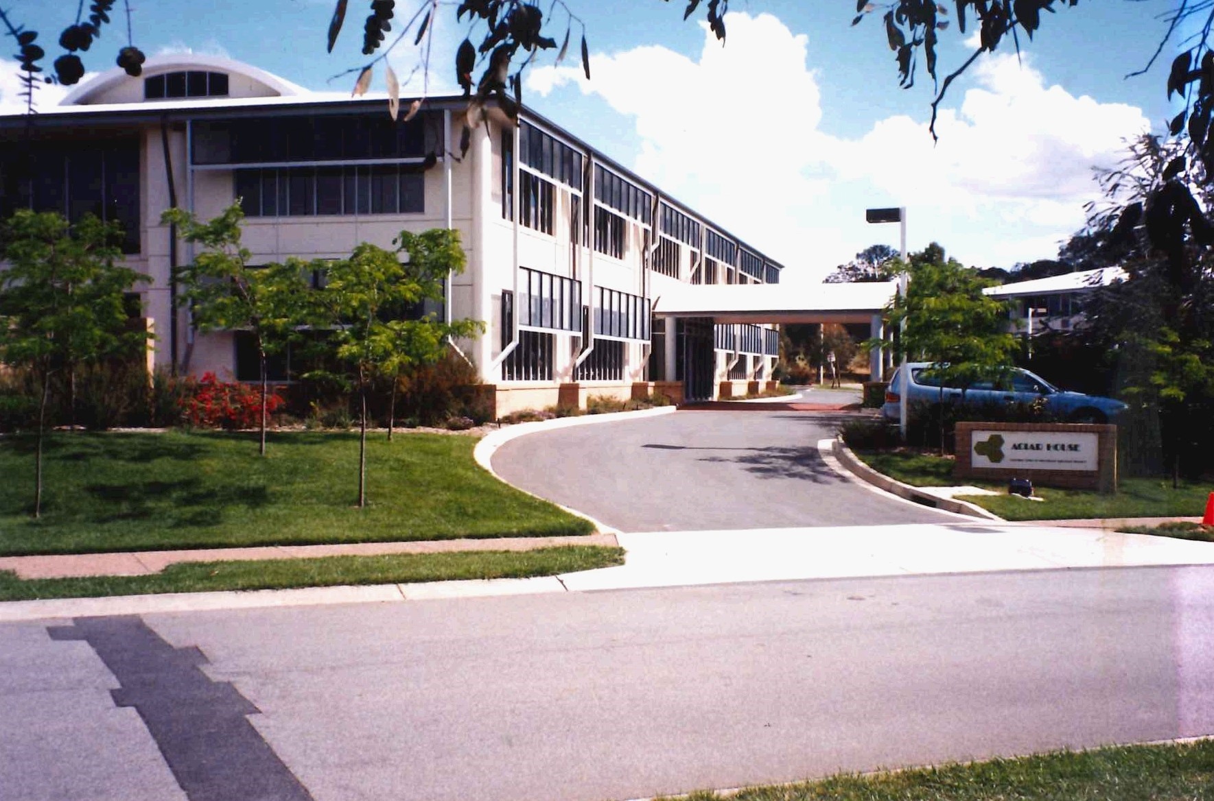 A building with a driveway and a parking lot