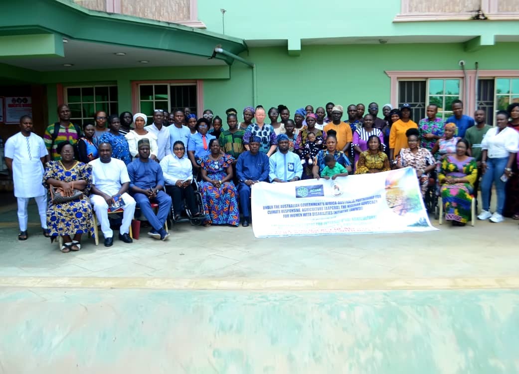 A group of people sitting together behind a project banner