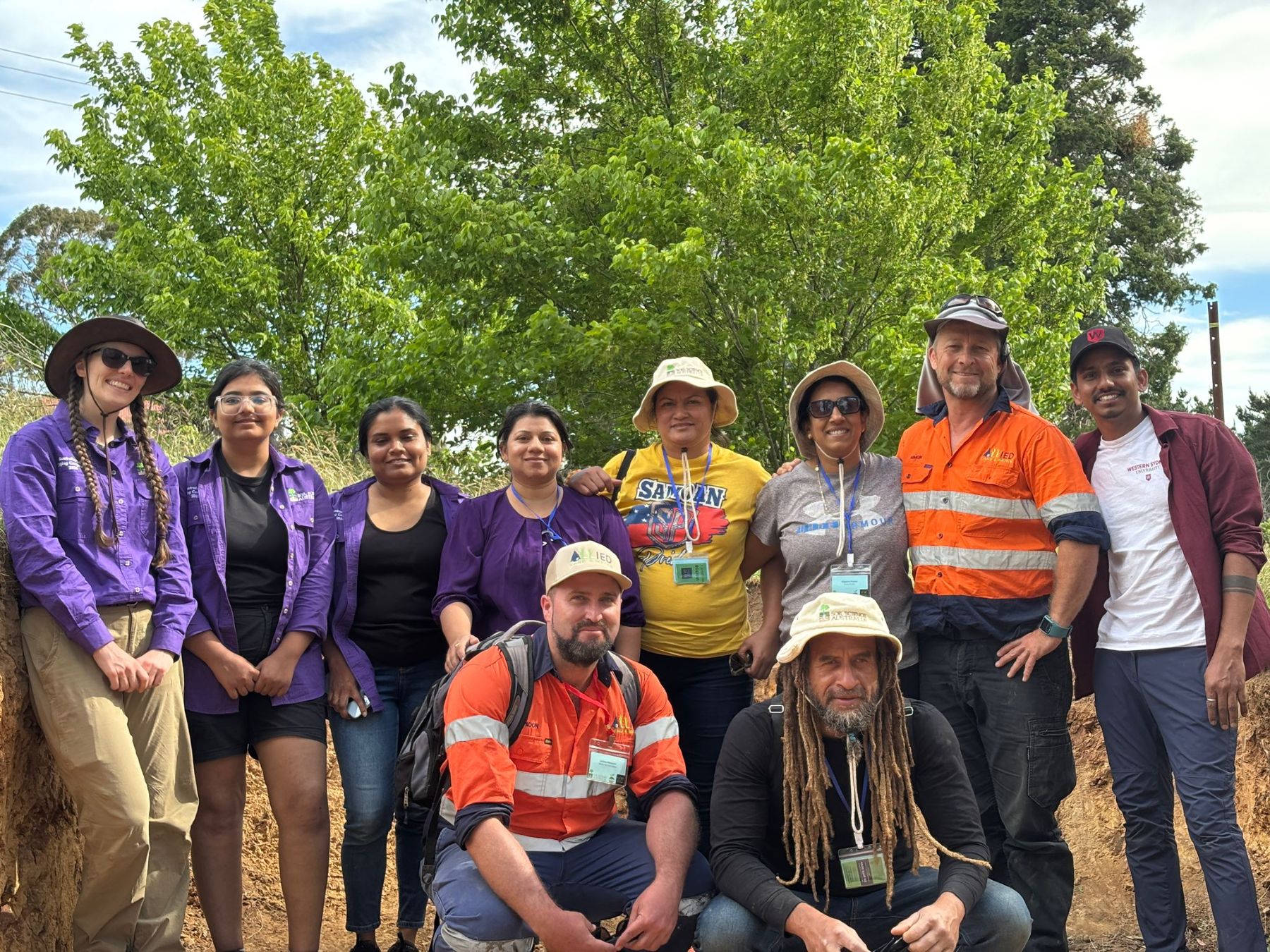 Team Pacifica standing outside together smiling for a photograph. 