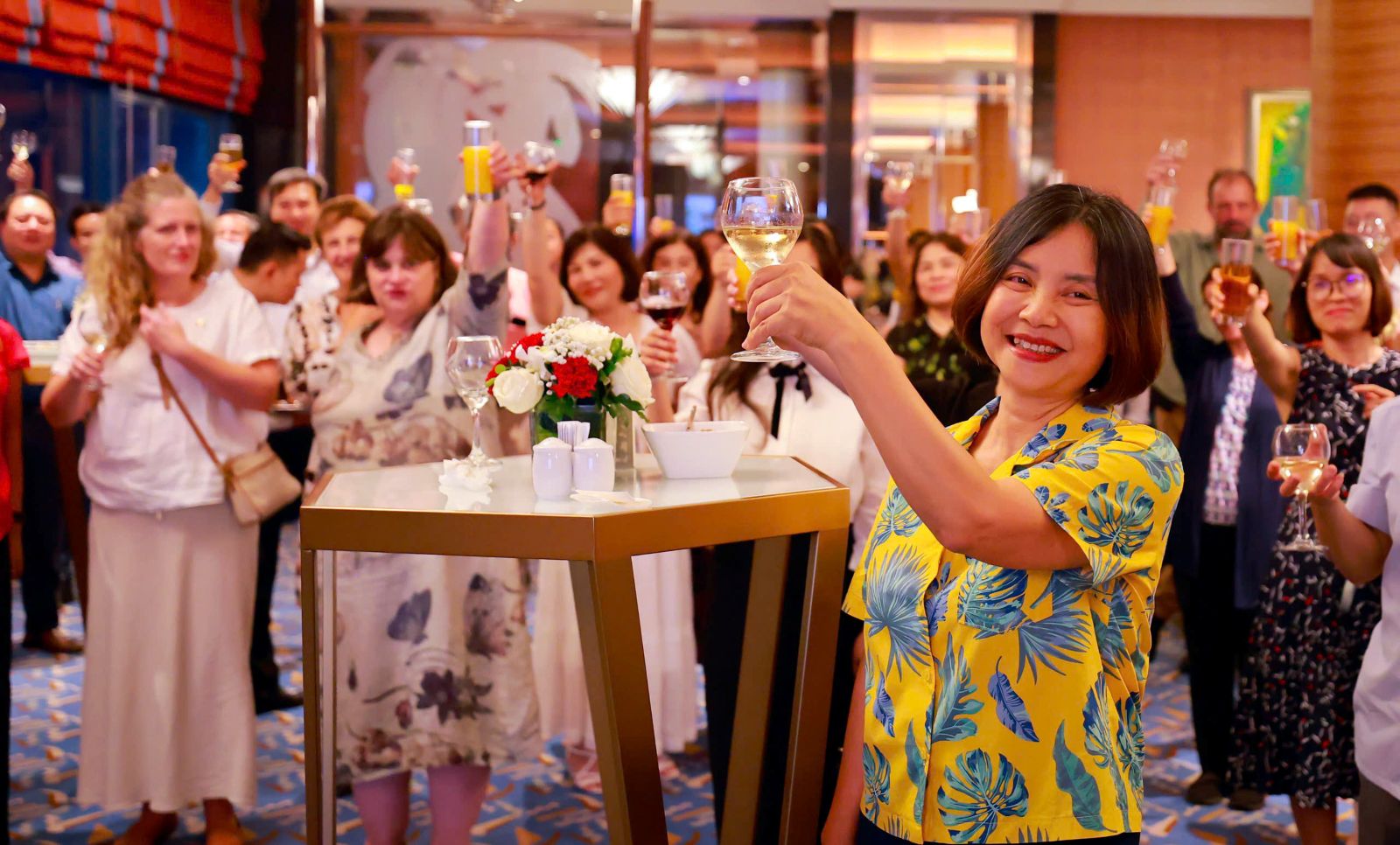 Woman hold glass surrounded by colleagues
