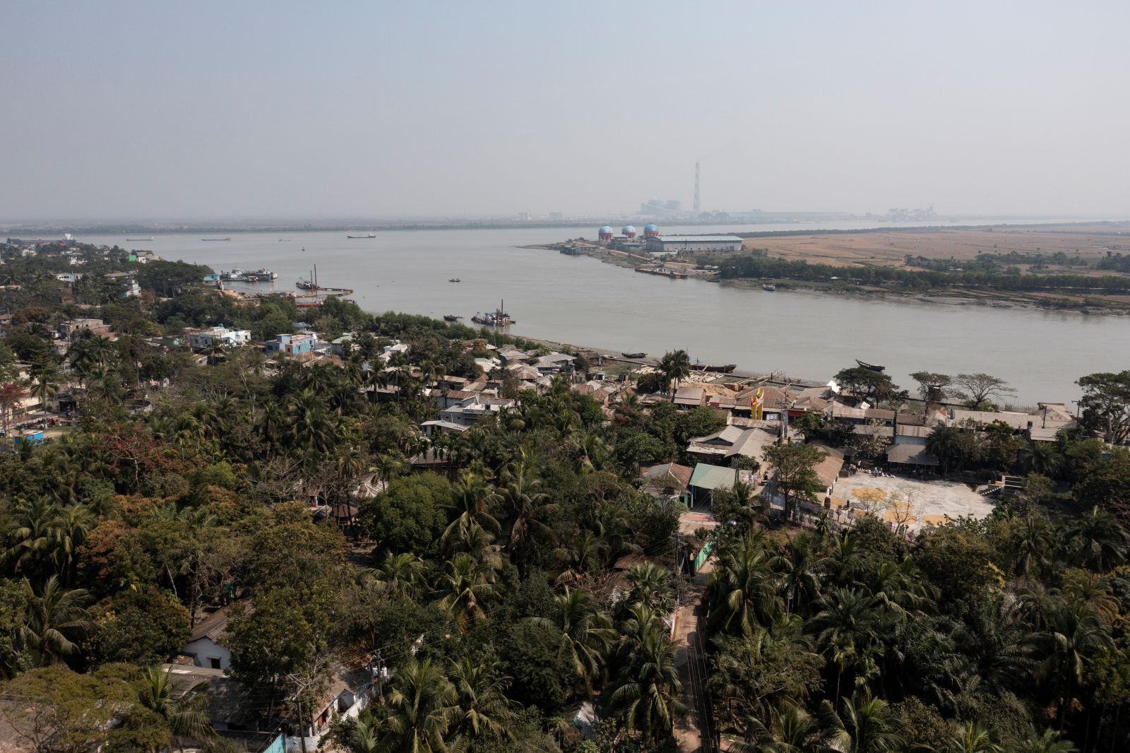 Wide river flowing beside a green, low‑lying town.