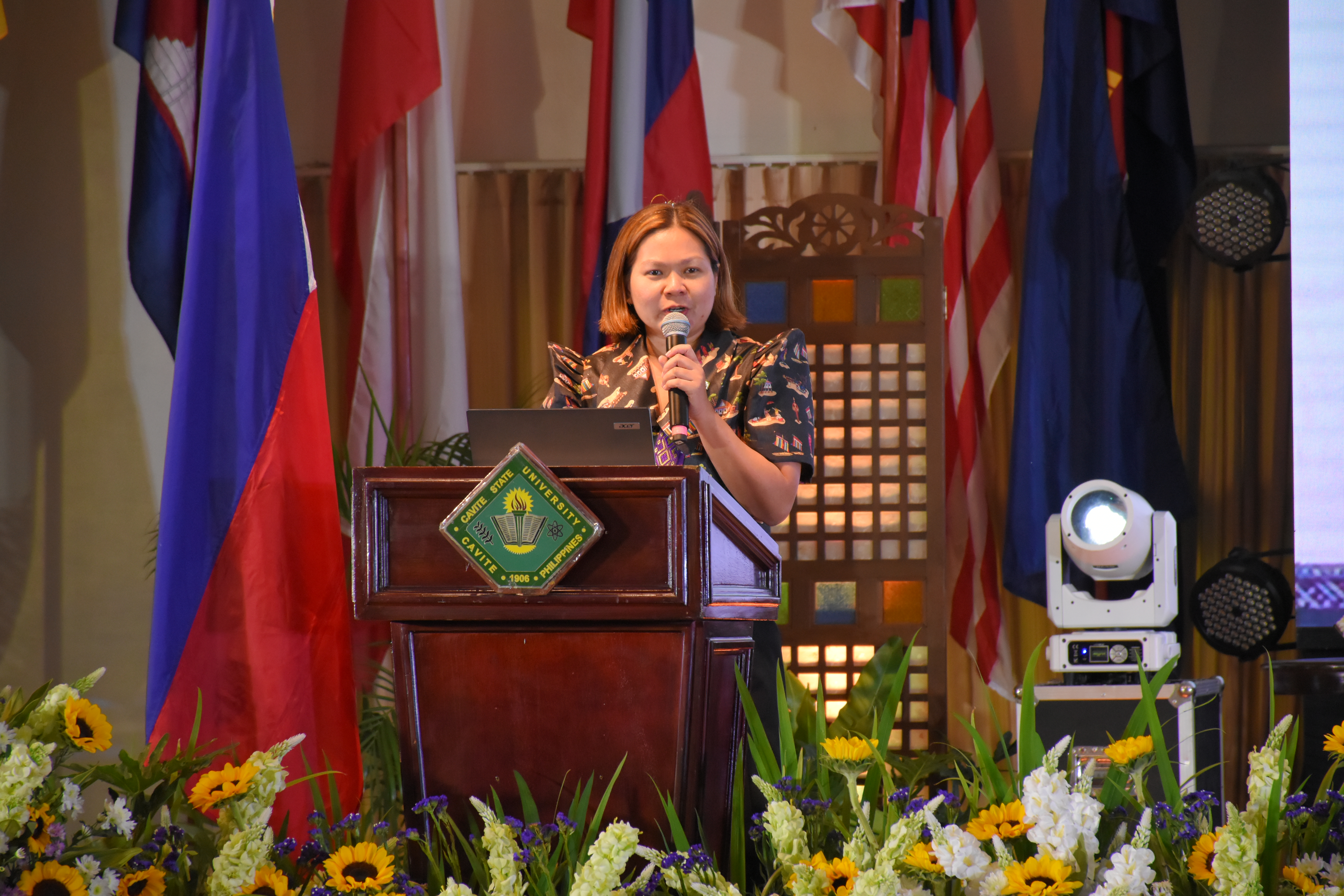 Female speaker presenting at a podium during a conference